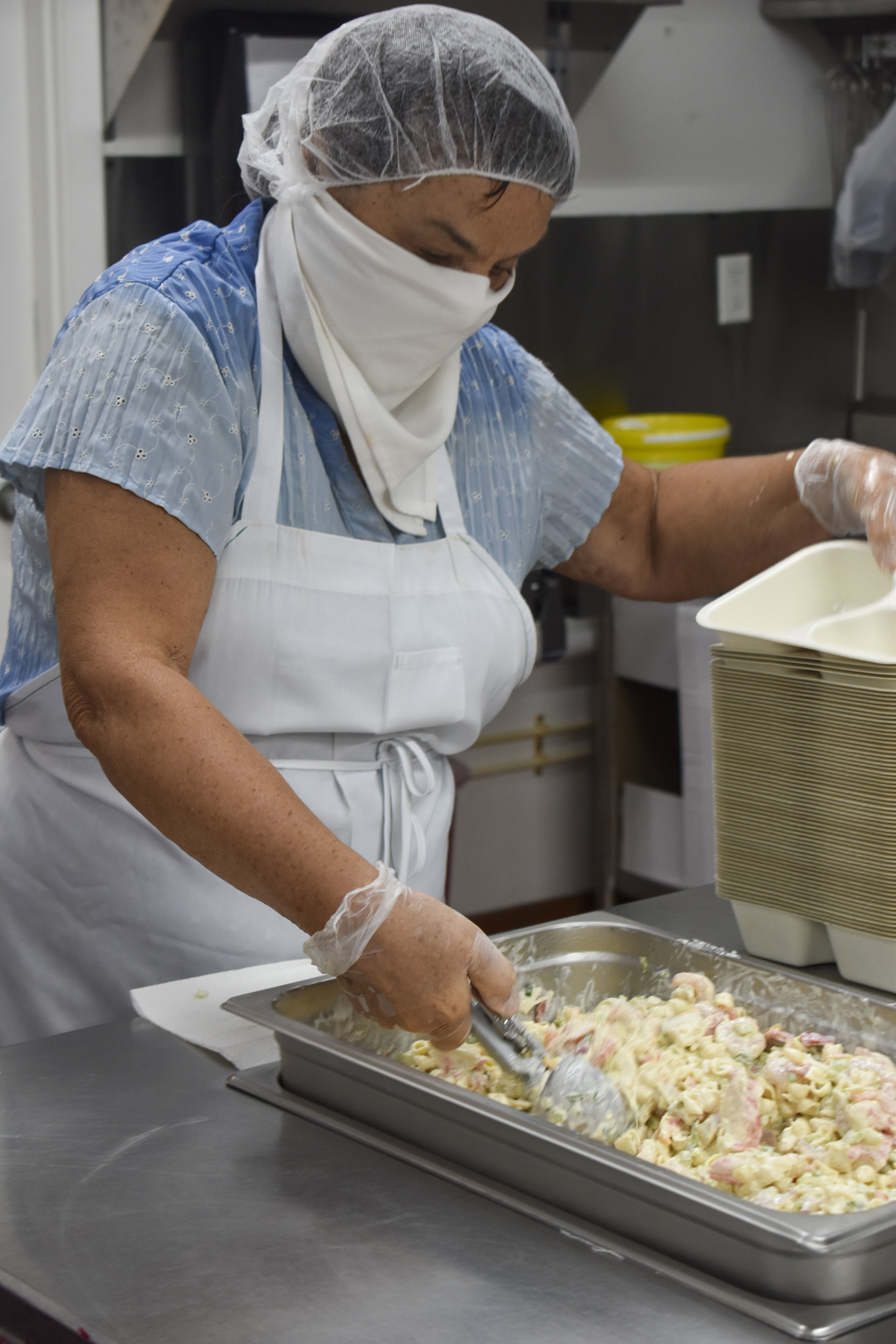 Lidia Patrina scoops the shrimp salad into the meal containers.