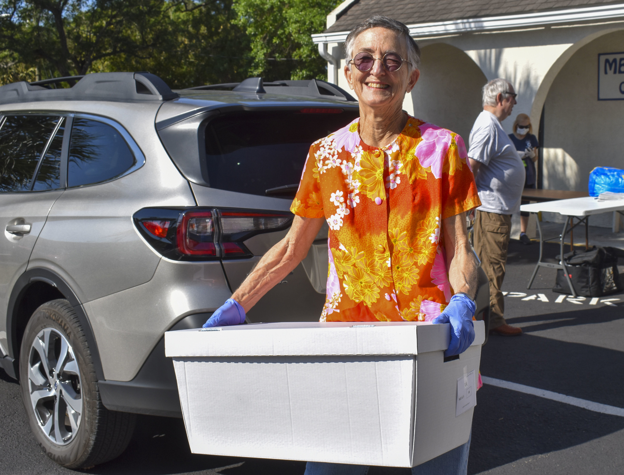 Volunteer Lucinda Brown carries her route meals to her car.