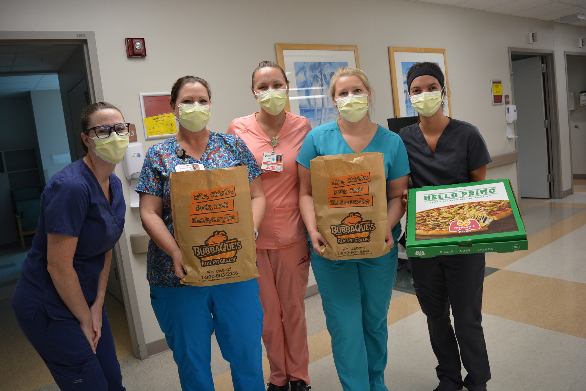 Medical surgical floor nurses Sarah Curtis, Samantha Edelman, Kari Jones, Dusty Carpenter and Noelle Clark happily take donated lunches of pulled pork sandwiches and pizza.