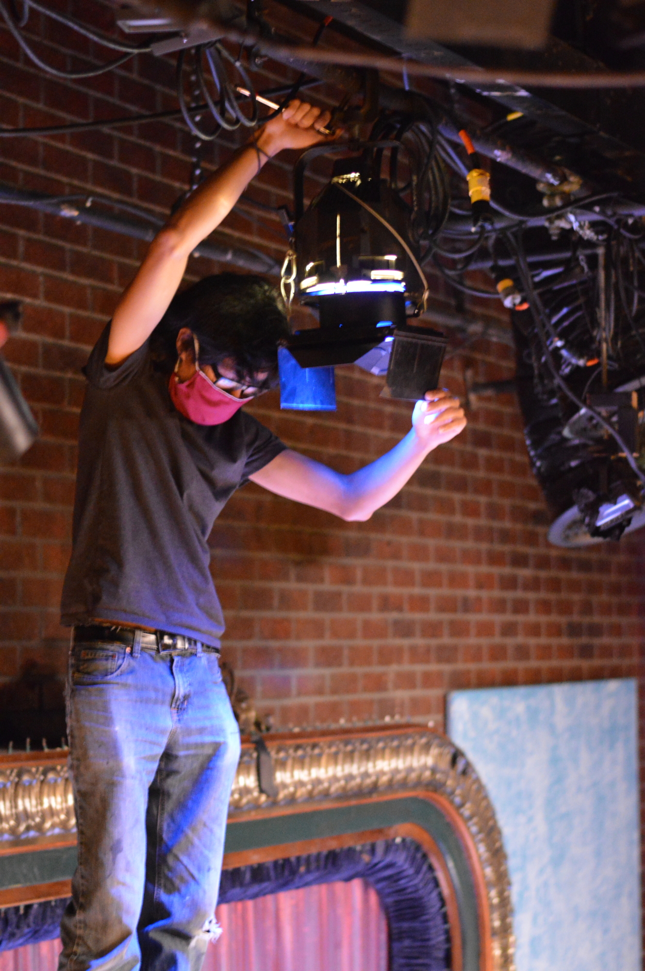 Lighting fellow Justen Zhang works with lighting settings in Florida Studio Theatre. Photo courtesy Sarah Haley.