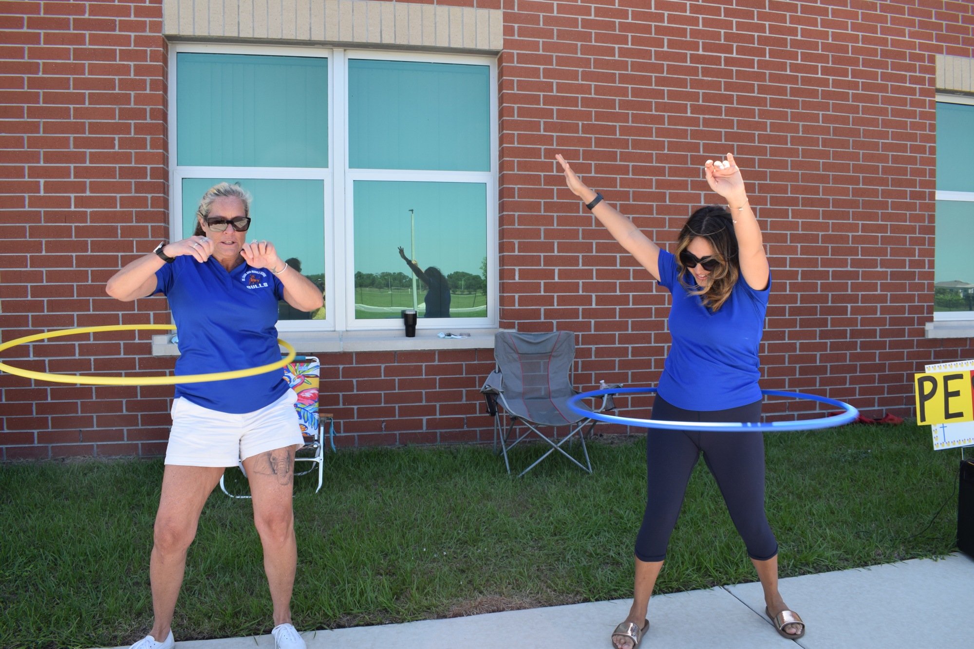 Wende Wicks and Jillian Cucci, intensive reading teachers at Mona Jain Middle, hula hoop during the eighth grade drive-thru parade. The parade was a highlight of the school year for some teachers. File photo.