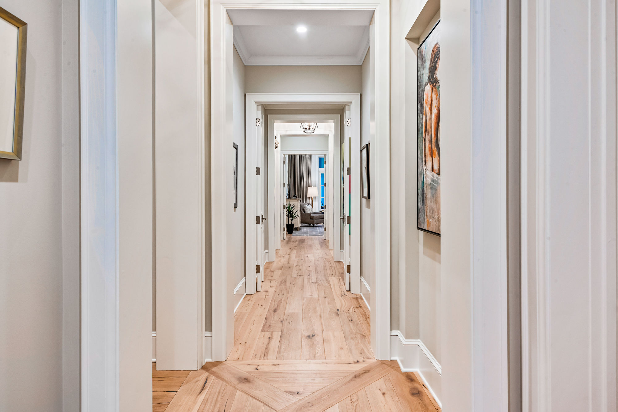 Wooden floors add warmth and showcase the home’s West Indian inspiration. Here, a hallway connects the master bedroom with an office and exercise room.