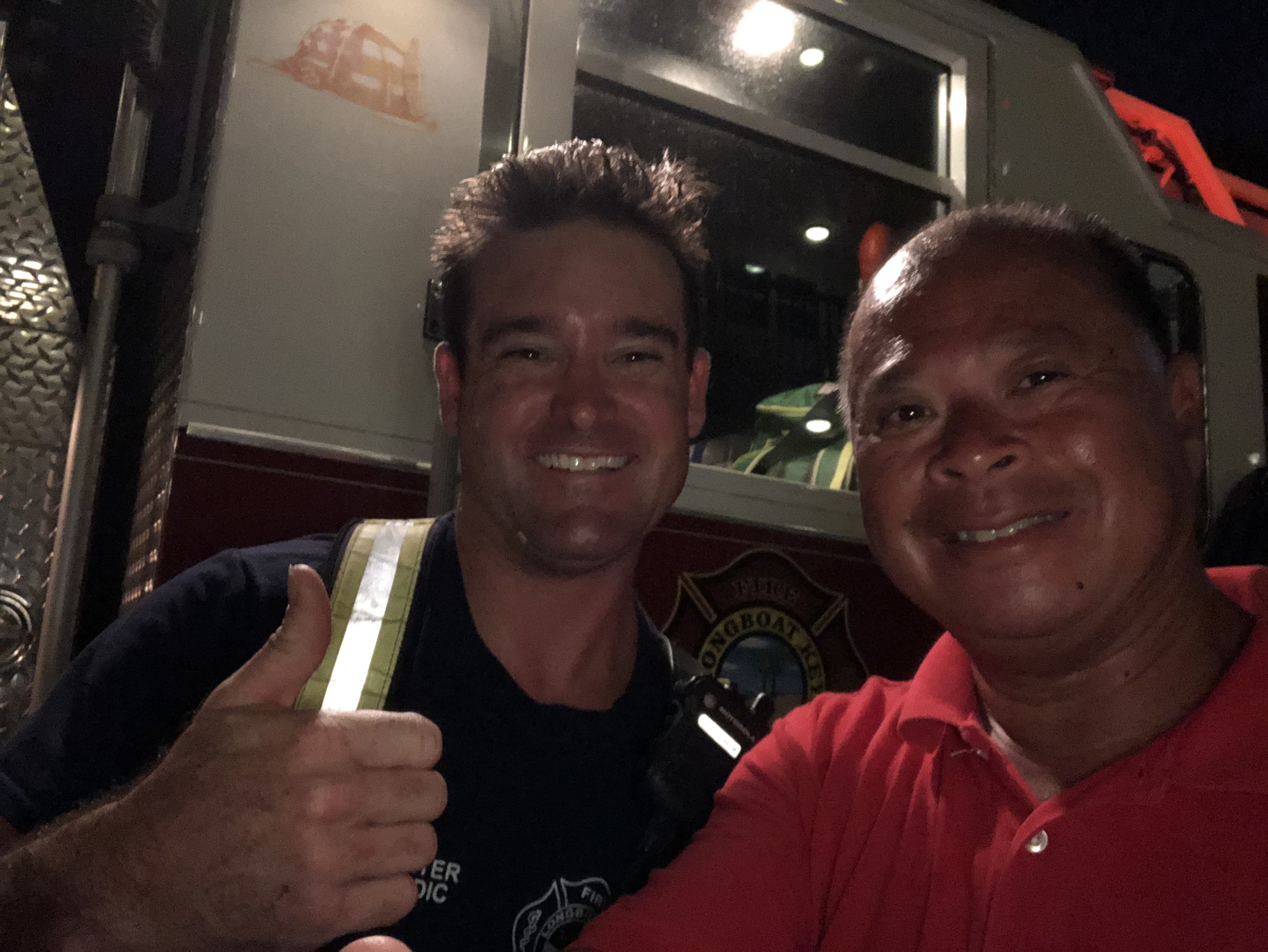 A Longboat Key firefighter (left) poses for a photo with Dean Congbalay (right).
