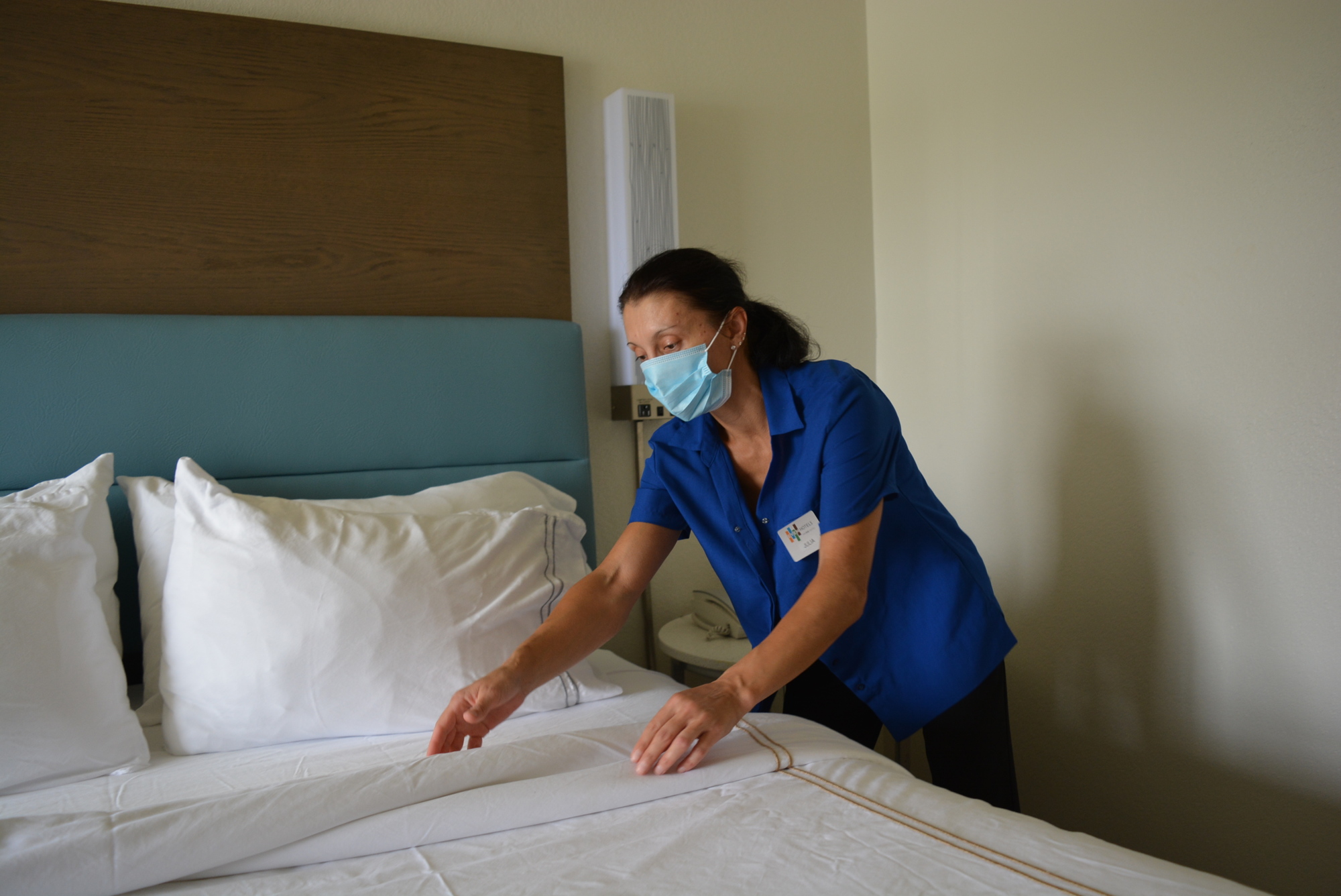 Housekeeper Julia Minayeva prepares a room at EVEN Hotel for its next guest. The hotel was sold-out for Labor Day weekend for only the second time since the pandemic began.