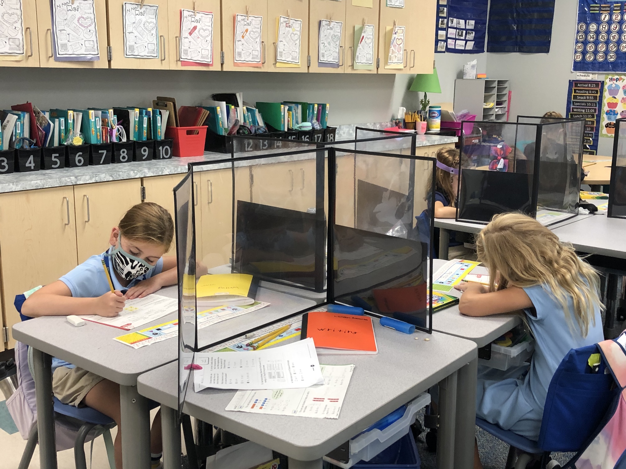 Second graders Aubri Darpino and Ella Baas are socially distant while working on assignments. The desks have casters, which allow teachers to easily move them so students can collaborate while also being safe.