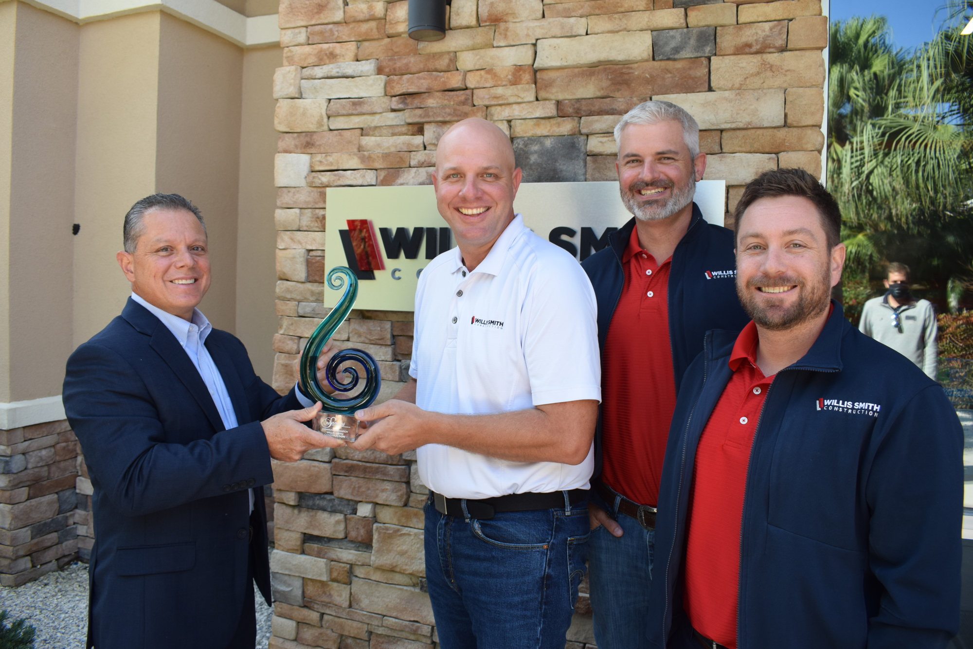 Dom DiMaio, the president and CEO of the Lakewood Ranch Business Alliance, presents the Community Champion-Company award to Willis Smith executives David Otterness, Brett Raymaker and Taylor Aultman.