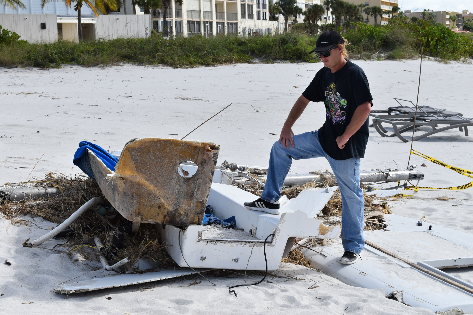 Sea Tow employee York Graham examines the sailboat debris in Longboat Key.