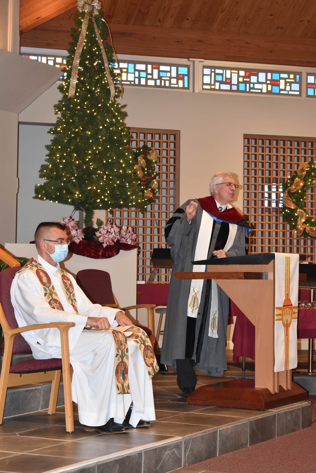 Father Robert Dziedziak sits while the Rev. Norman Pritchard speaks. 