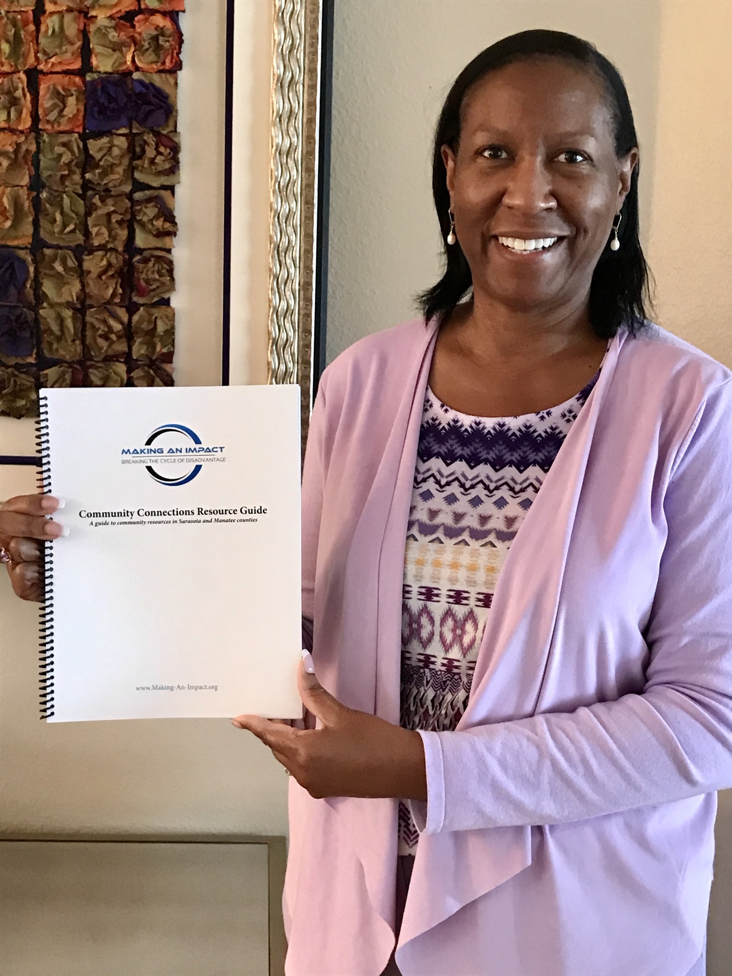 Making an Impact board chair and registered nurse Victoria Kasdan holds the Community Connections Resource Guide, includes background and contact information on over 200 local agencies organized into 17 categories of service.
