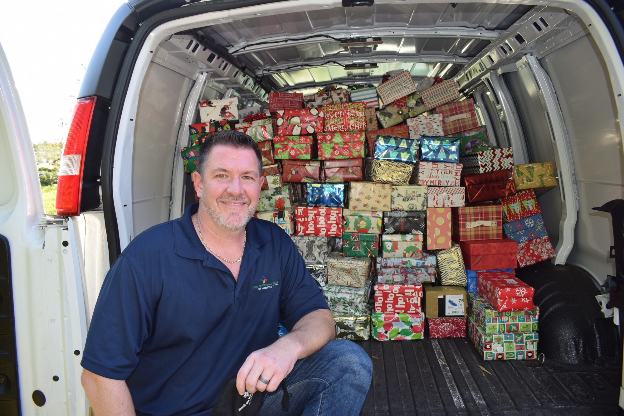 Bryan Lipps, the vice president of strategic programs for Meals on Wheels Plus, takes a break from packing shoebox donations into a van.