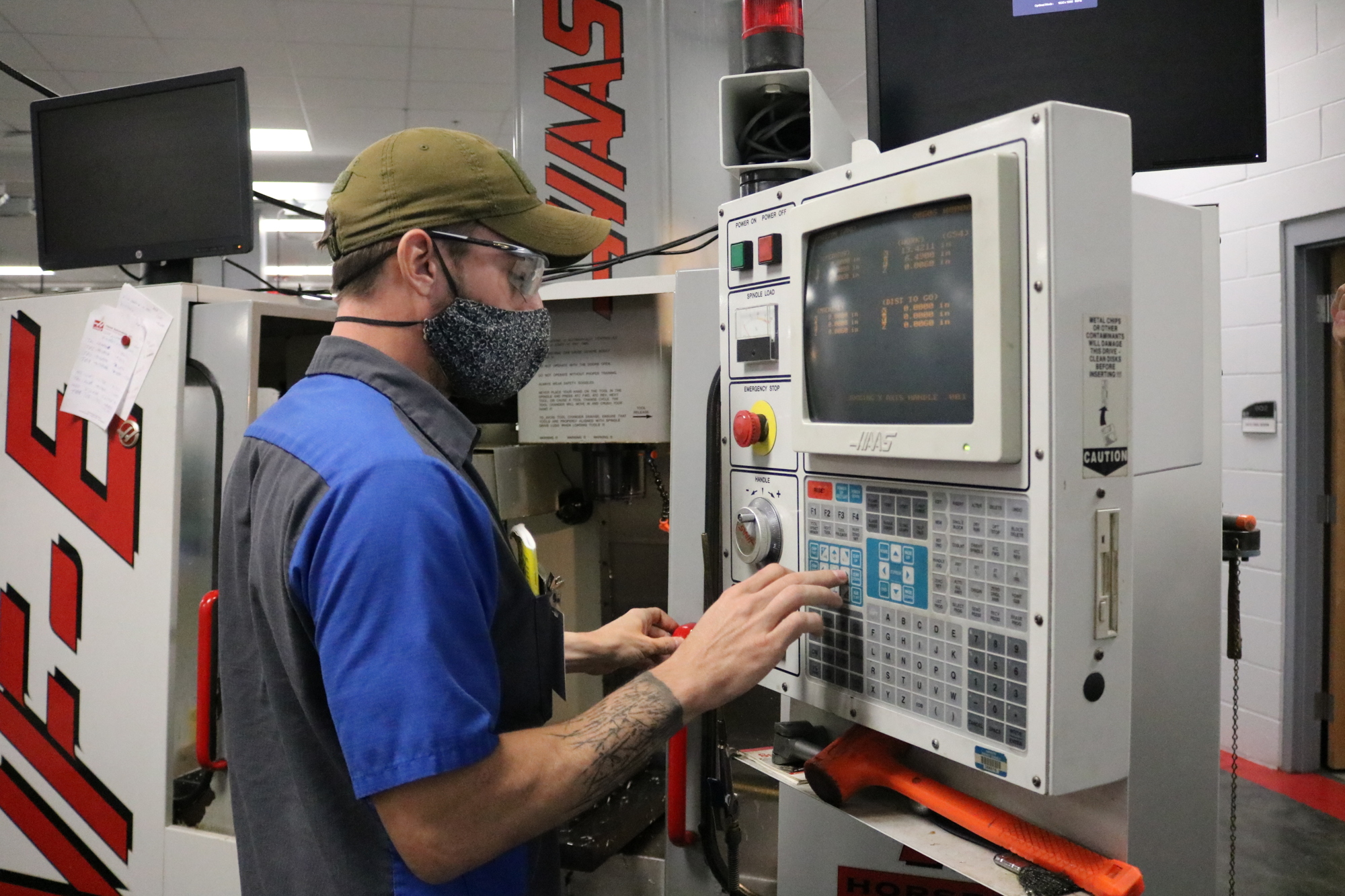 Bryan Monville, a CNC Production Technology student, operates a CNC mill to produce a part for a U.S. Department of Defense contractor. Courtesy photo.