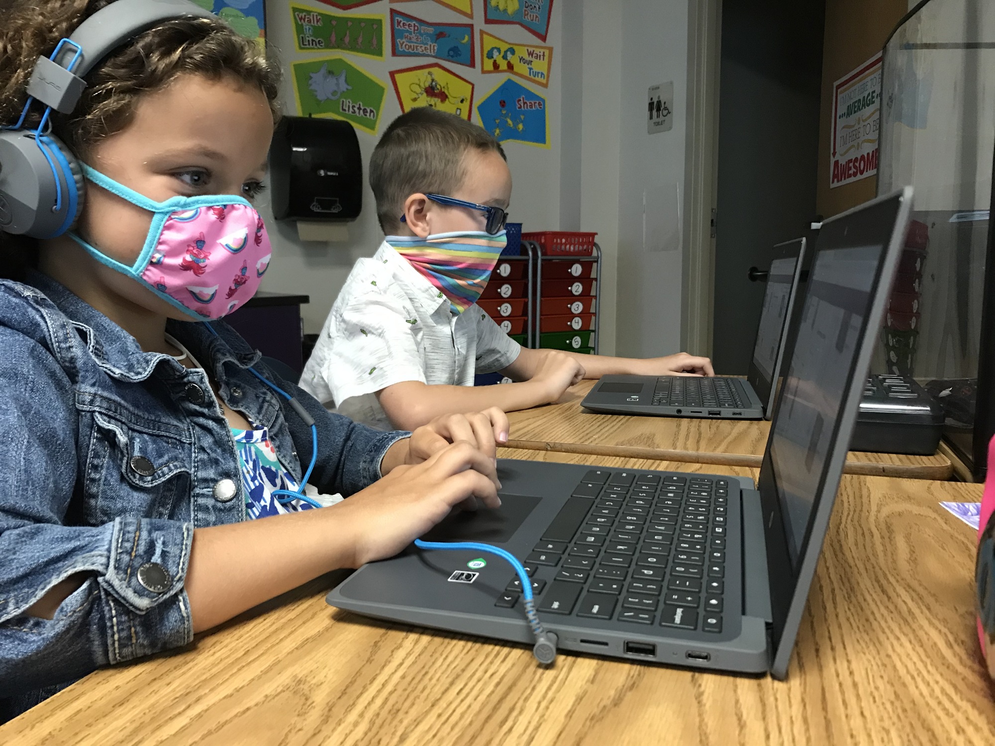 Madelyn Hall and Patrick Danielcak, first graders at B.D. Gullett Elementary School use laptops to learn how to access digital books from the public library. Courtesy photo.