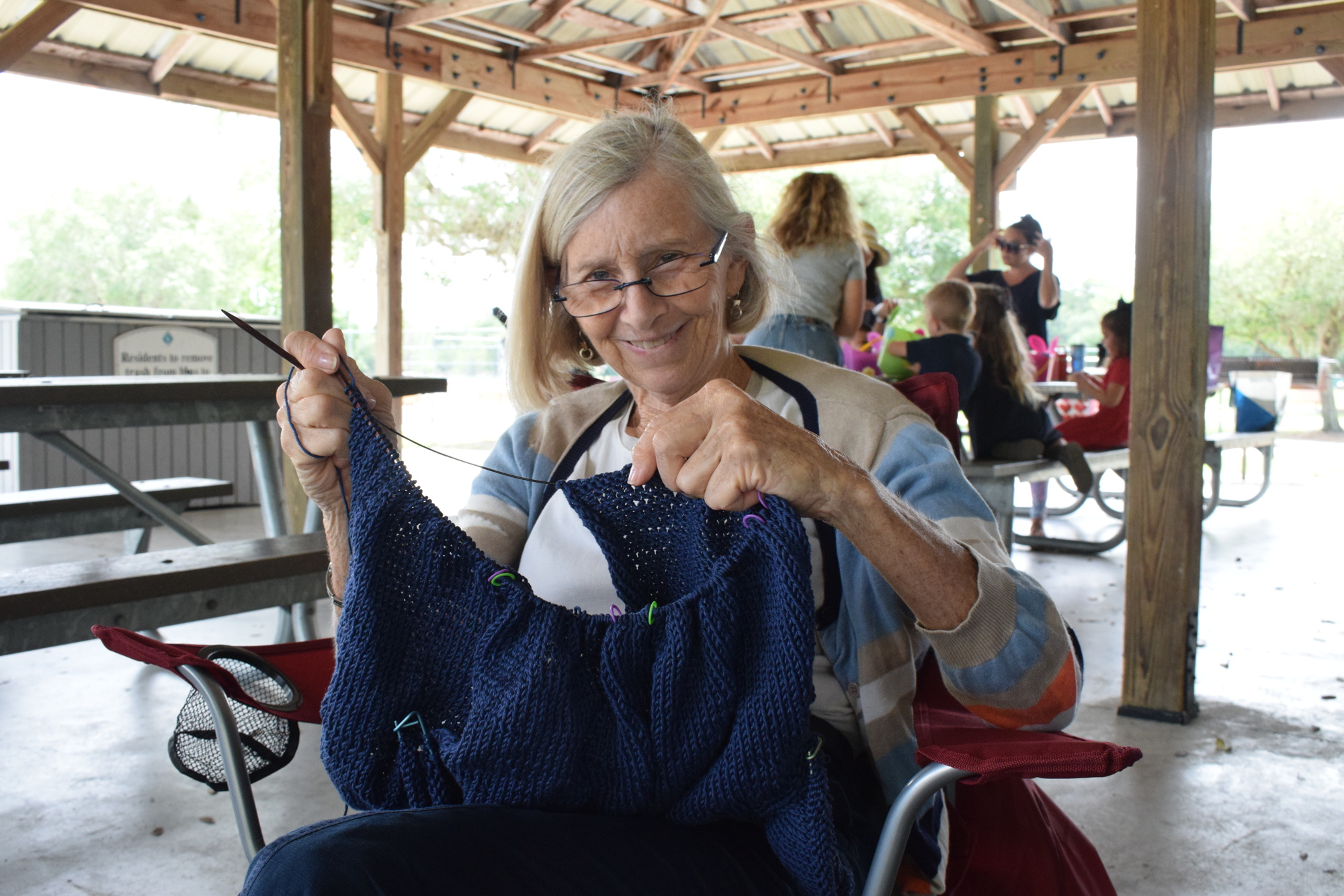 University Park's Laurie Roshfled is knitting a sweater in a method she has never tried before. She's knitting the sweater from the neck down when she usually works from the waist up.