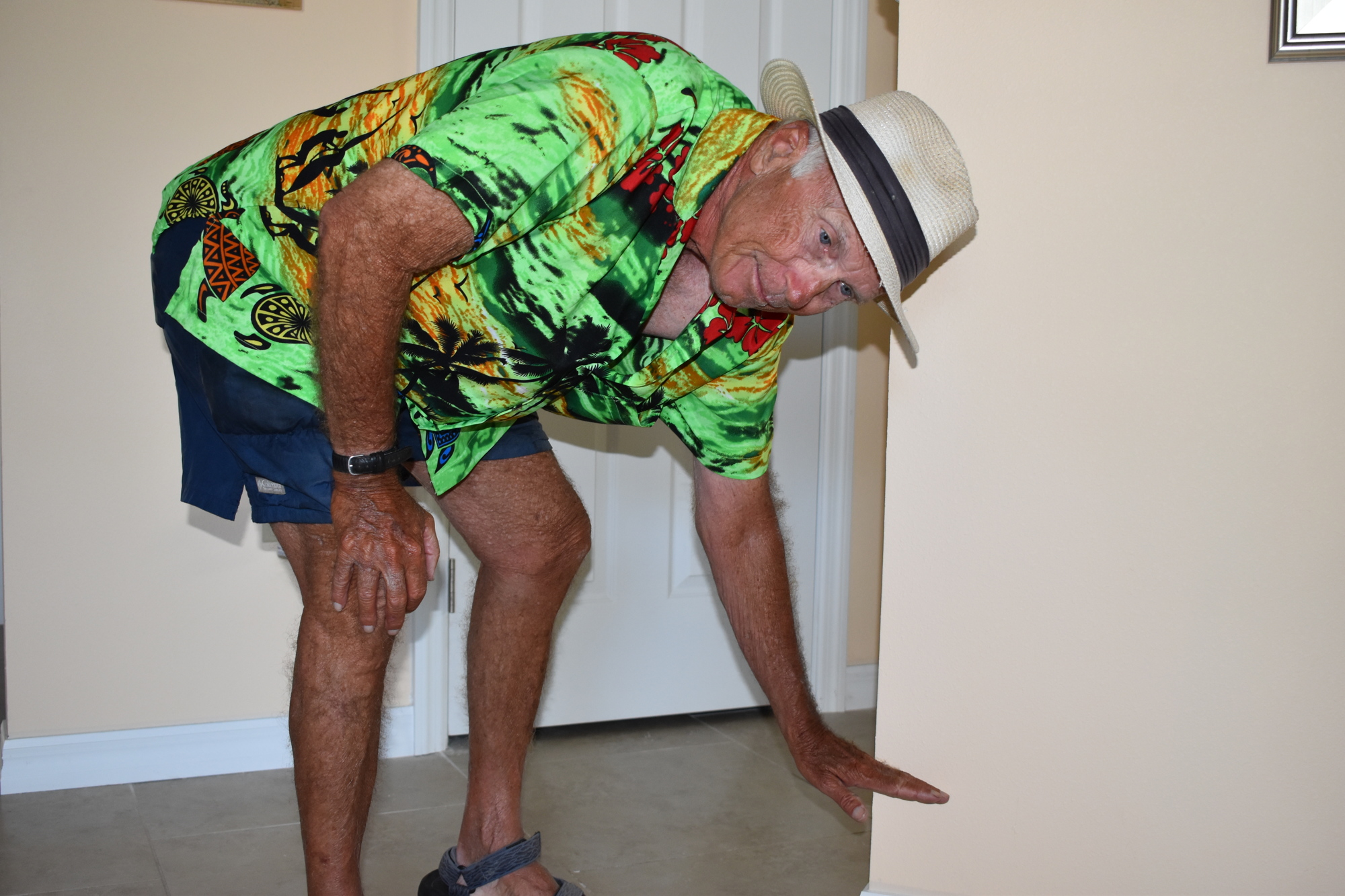 Fred Kagi demonstrates about how high the stormwater runoff was inside his home during Tropical Storm Eta.