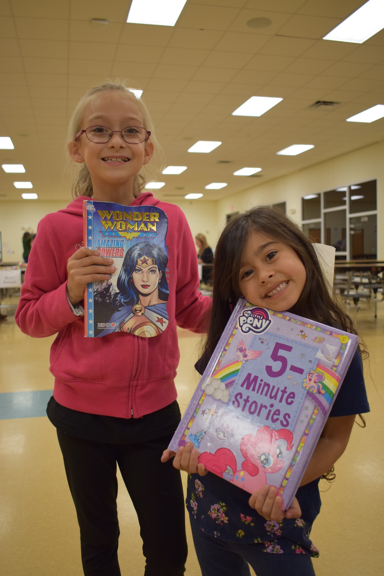 E'Lyiah Cruz, a third grader at Myakka City Elementary School, and Lilliana Christie, who is 4, take home free books at a literacy night. The School District of Manatee County will host a third grade reading camp this summer. File