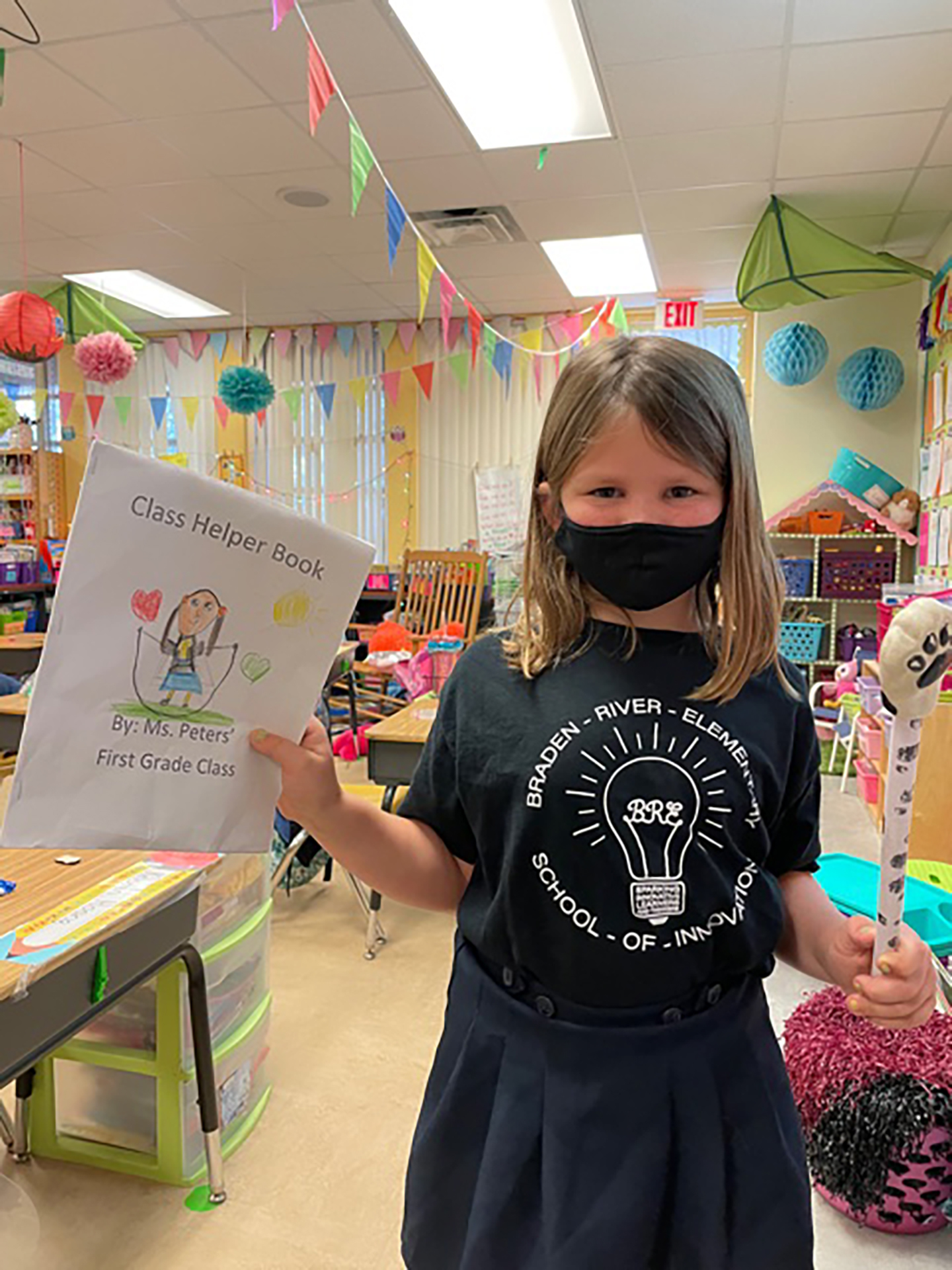 Raelynn Wilson, a first grader at Braden River Elementary School, shares her Class Helper Book. Elementary school students like Wilson will have fewer early releases next year. Courtesy photo.