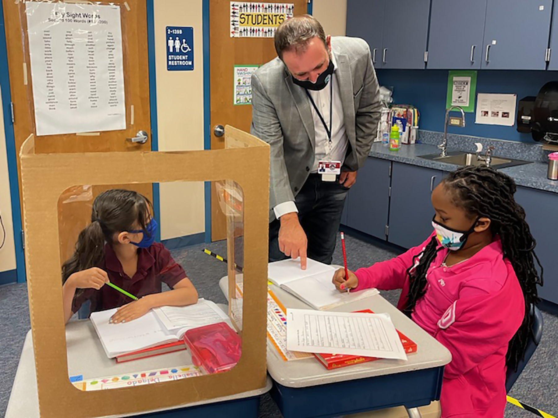 Palm View K-8 School Assistant Principal James Dougherty helps students with an assignment. Dougherty will be helping students at William H. Bashaw Elementary School next year as the new principal. Courtesy photo.