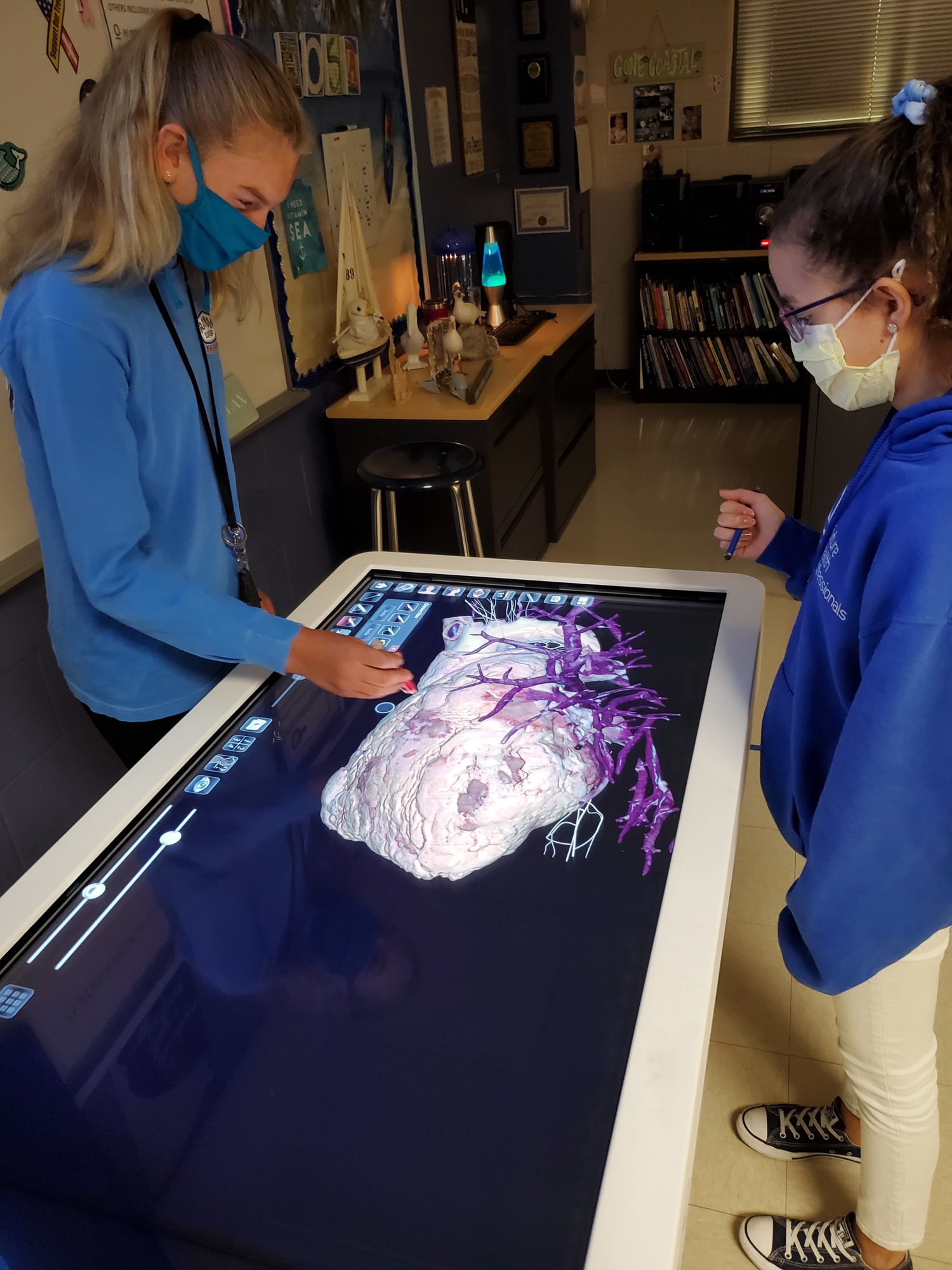 Savannah Adams and Victoria Santaella, students at R. Dan Nolan Middle School, use an anatomage table to label the different parts of the heart. The school was able to purchase an anatomage table using the millage. Courtesy photo.