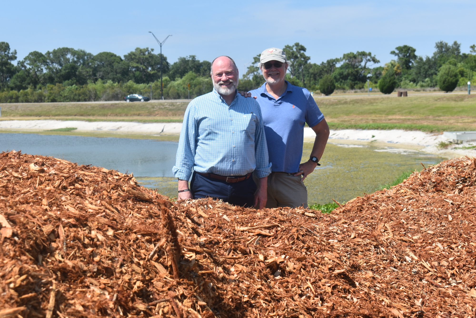 Suncoast Aquatic and Nature Center Associates President and CEO Tomás Herrera-Mishler and Southface Institute Science Advisor Charles Reith stand with a pile of mulch that will soon be used as the foundation for a microforest.