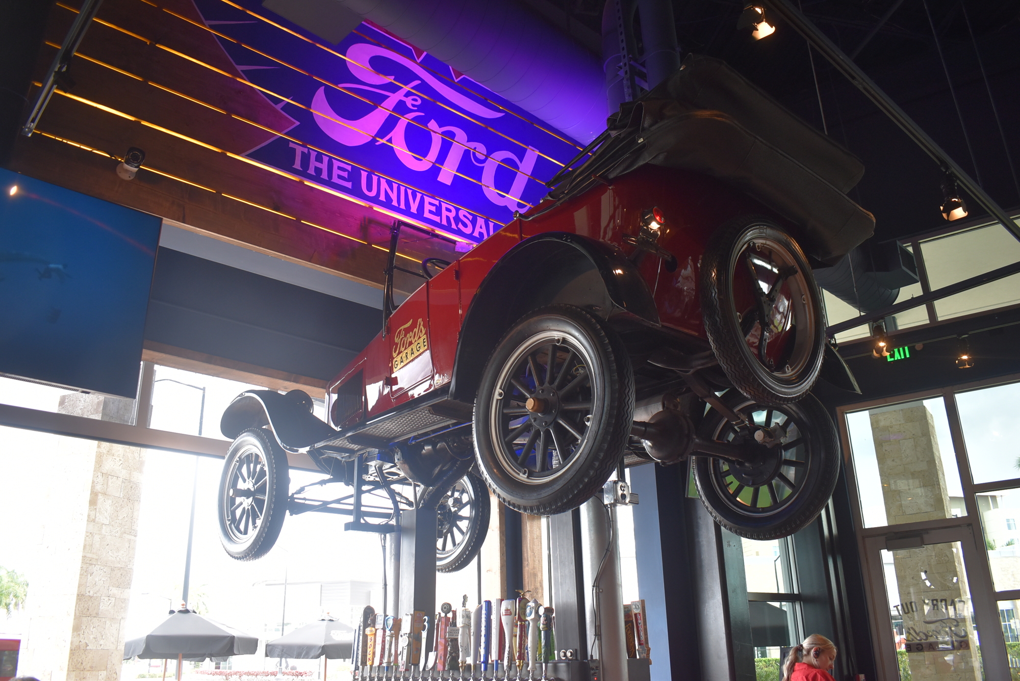 One of multiple vehicles that can be found inside Ford's Garage, a car sits propped above one of the restaurant's bars.