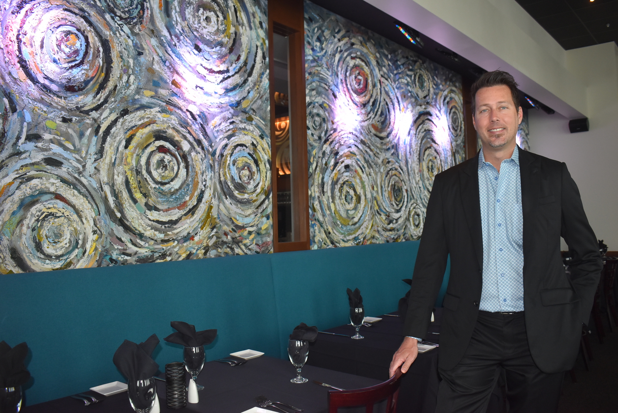 Selva Grill Co-owner Jeremy Osment stands in front of a mural inspired by Vincent Van Gogh's Starry Night. Osment said Selva Grill wants to provide an exotic dining experience for Lakewood Ranch-area residents.
