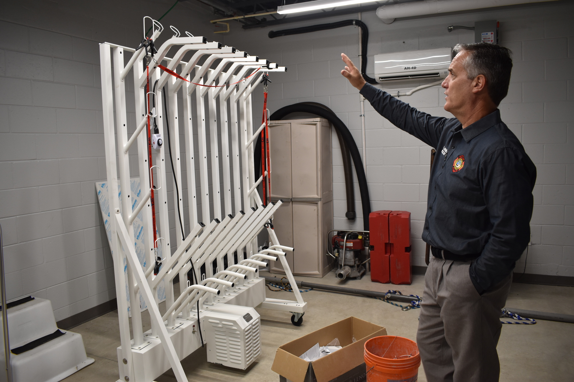 Fire Chief Paul Dezzi demonstrates how machinery will help dry firefighters' equipment.