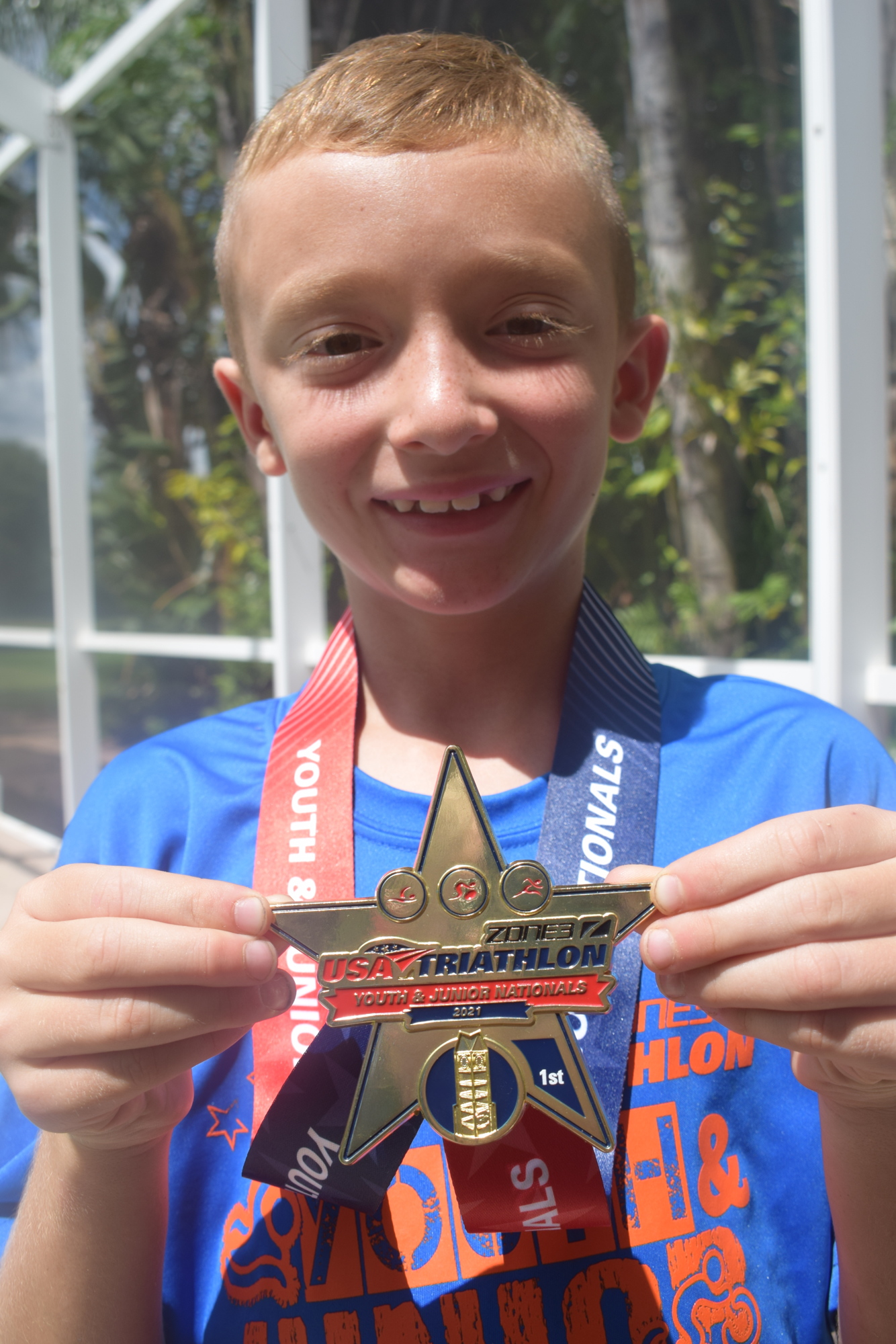 Aaron Westrip shows off the triathlon national championship gold medal he won. Photo by Jay Heater