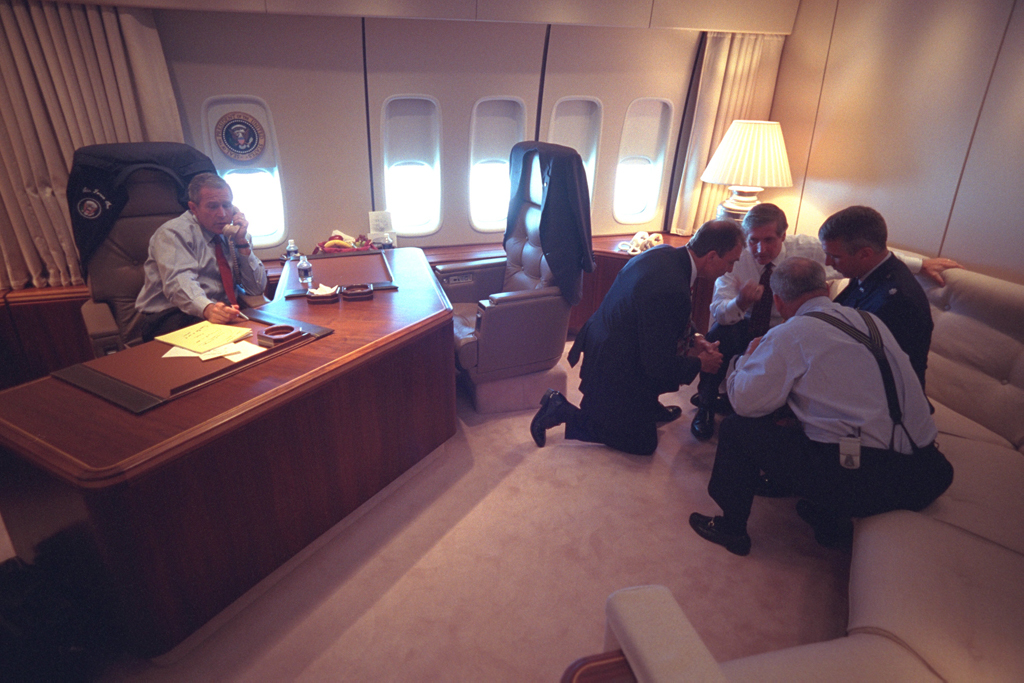 Aboard Air Force 1, President George W. Bush speaks with advisers (White House photo)