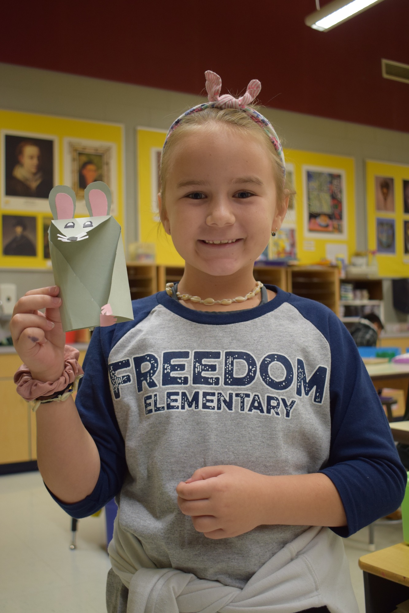 Alice Gustek, a Freedom Elementary School student, shows off her finished paper mouse sculpture. File photo.
