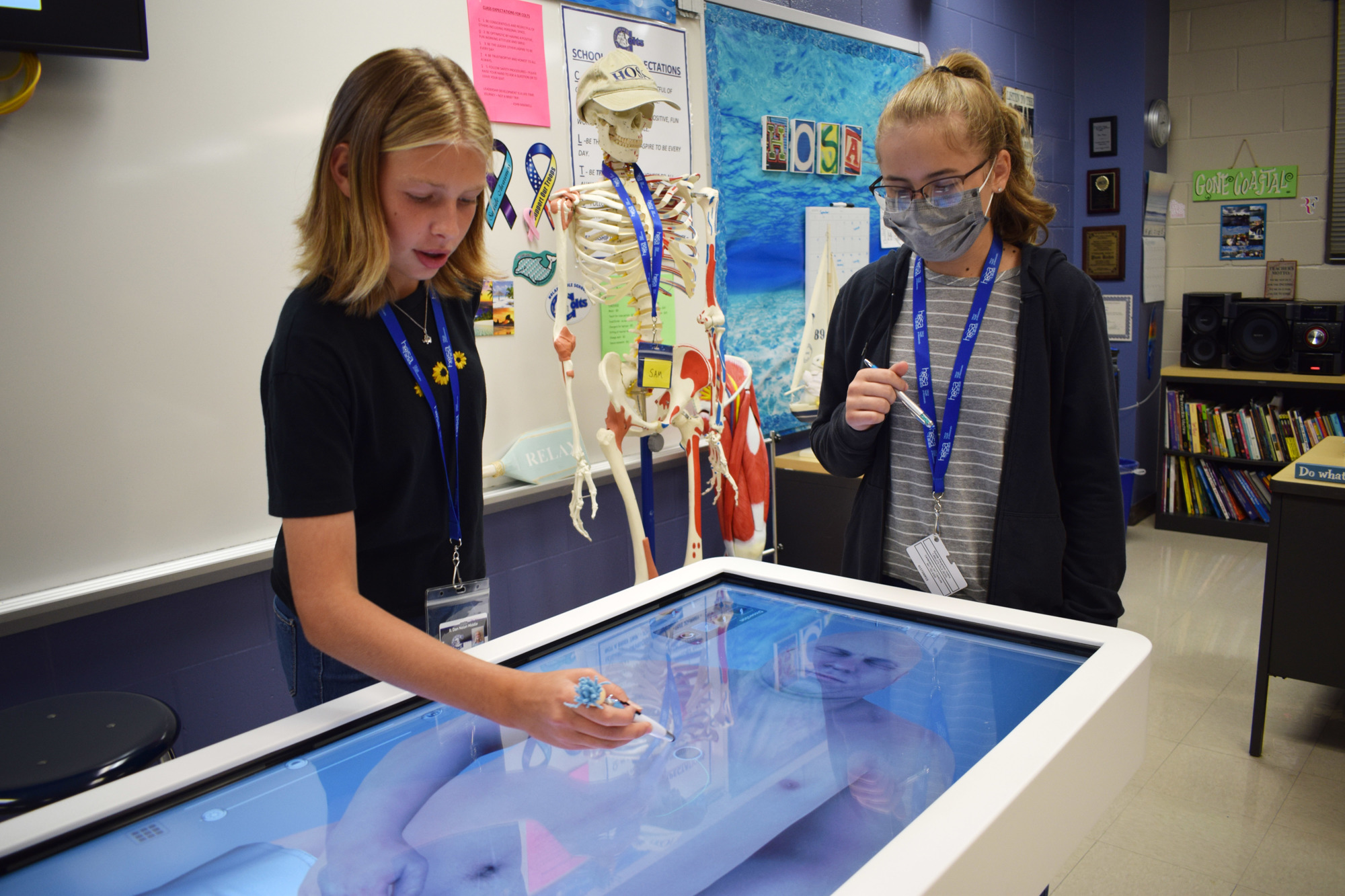 Payton Gee and Alexa Dziubek, eighth graders at R. Dan Nolan Middle School, take a look at a cadaver using the Anatomage Table that was purchased using funding from the School District of Manatee County's 1-mill ad valorem tax.