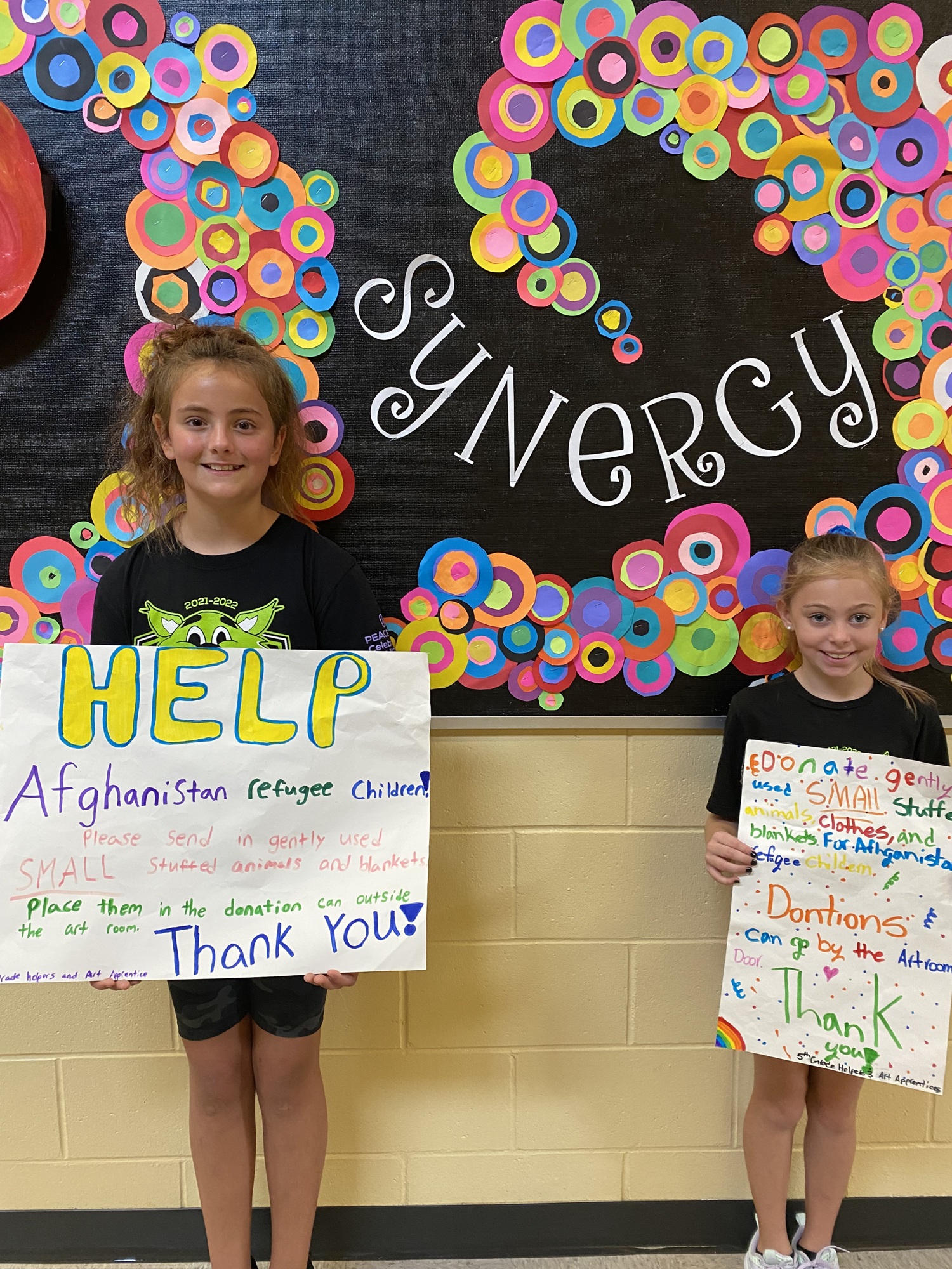 Fifth grader Evy Burge and fourth grader Sophia Tabb show off the posters that were created to promote the donation drive. Courtesy photo.