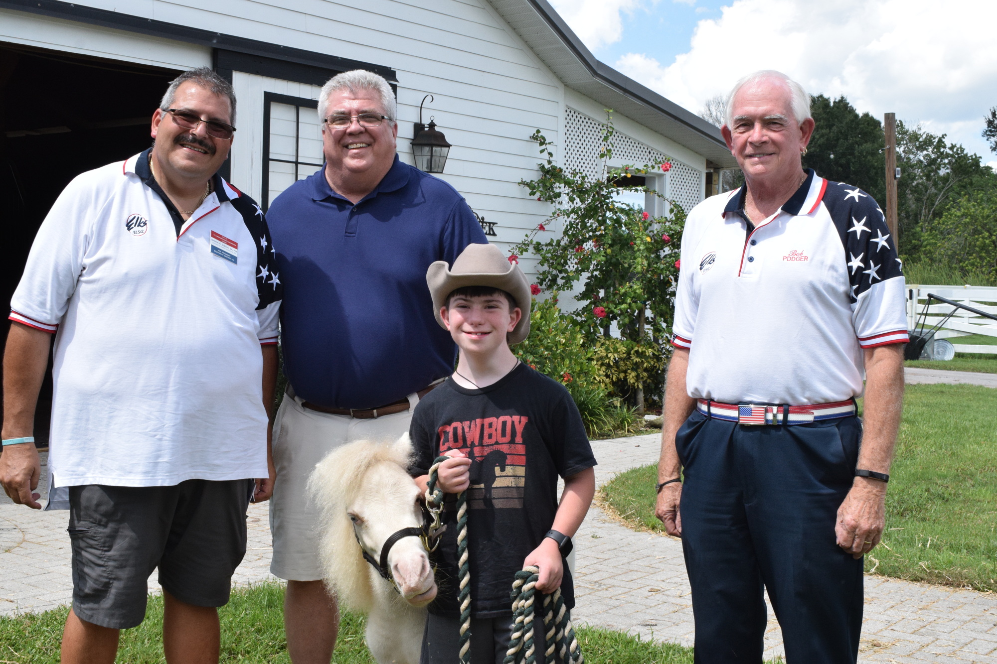 Elks Darrin Simone, Dan Tabor and Bob Erwin donate to Hooves with H.E.A.R.T. to support riders like Mason Kramer (front).