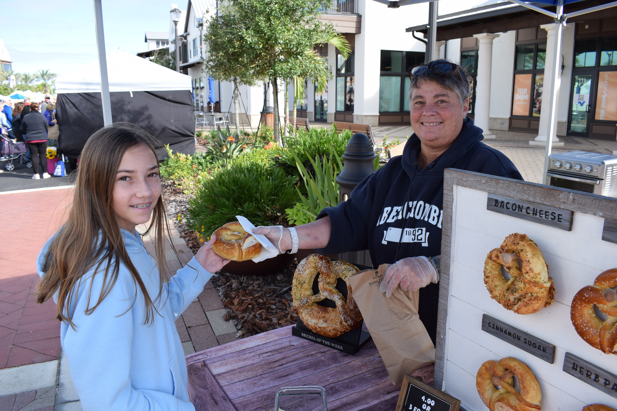 Lakewood Ranch's Addison Crutchfield, 11, gets a pretzel from Lorene Hill, the owner of German Brezel of North Port.
