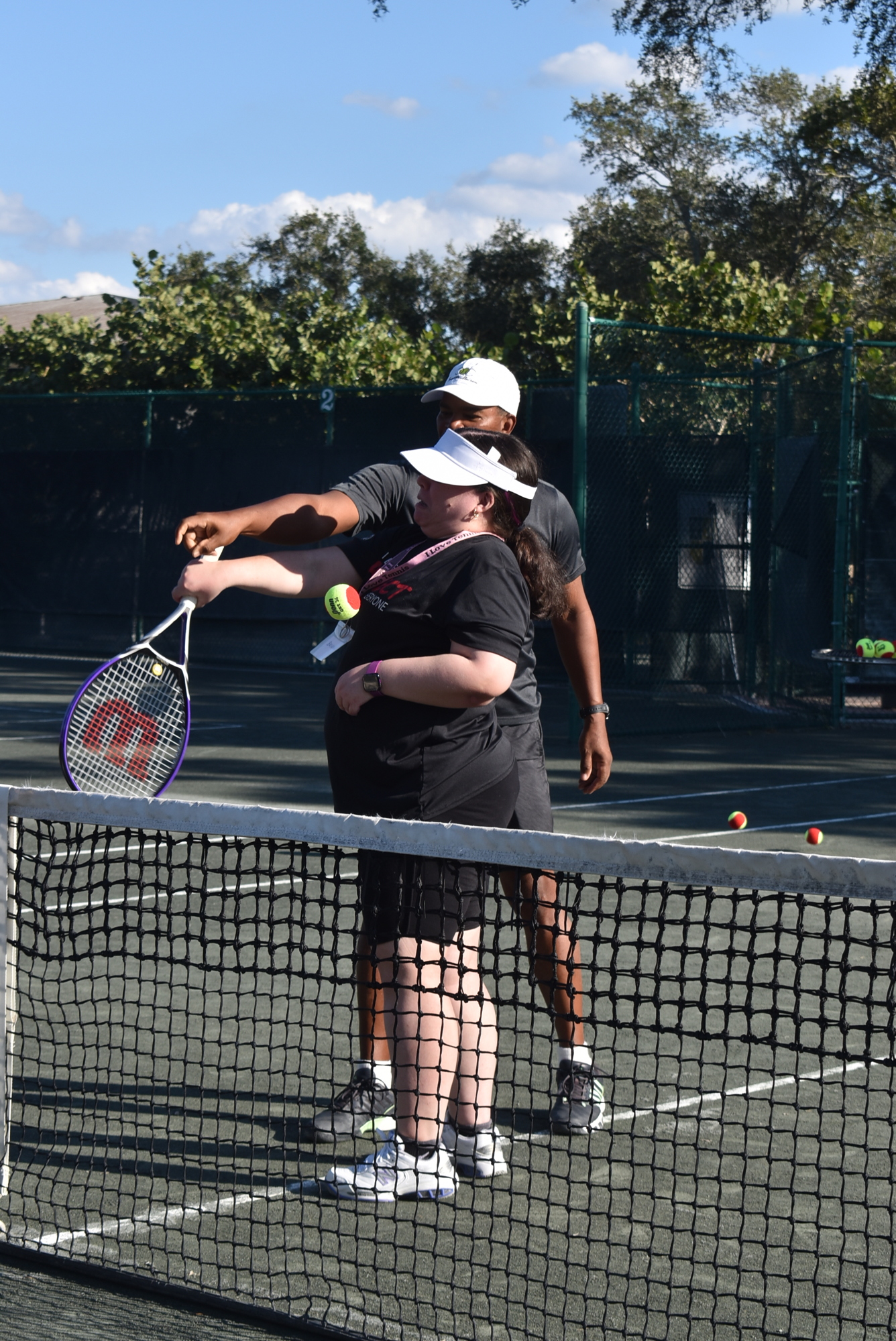Ron Shields helps Bryanna Schmidt with her racket.