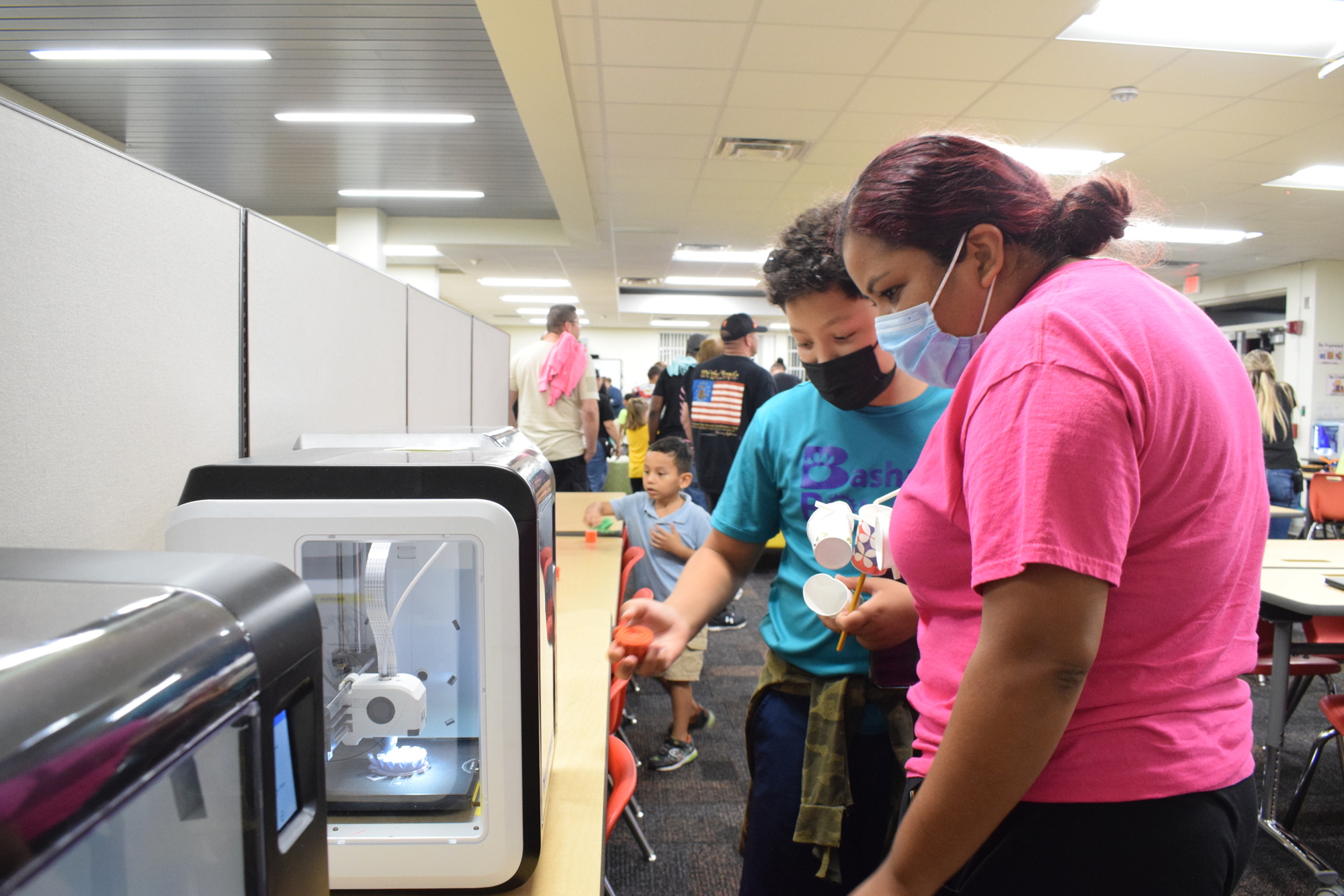 Angel Jimenez, a fifth grader, and Veronica Jimenez look at William H. Bashaw Elementary School's new 3D printers.