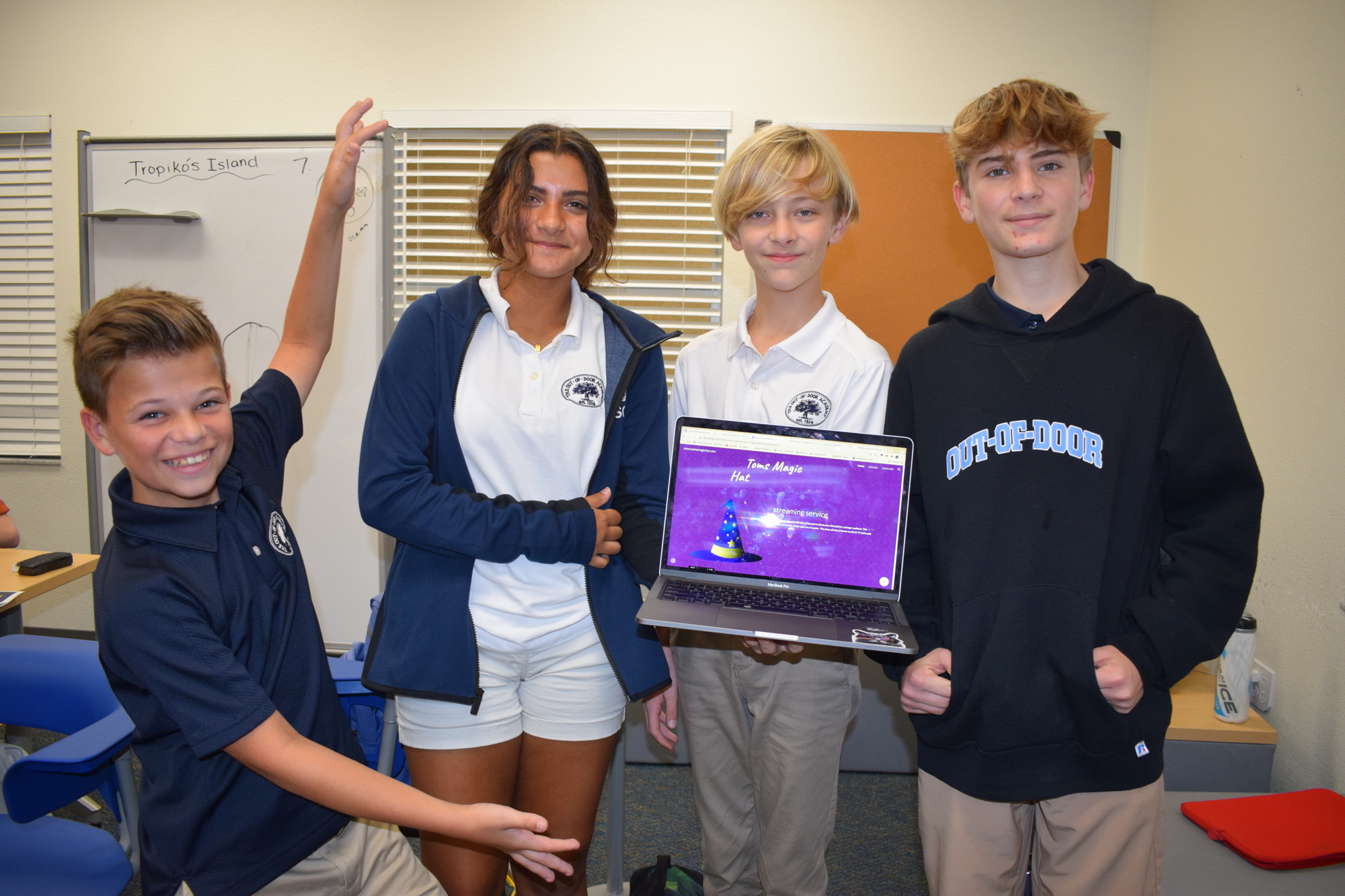 Seventh grader Tom Bergerat, eighth graders Bella Rojas and Mackey Kamiek and seventh grader Wilkes Borden show off the website for their show 