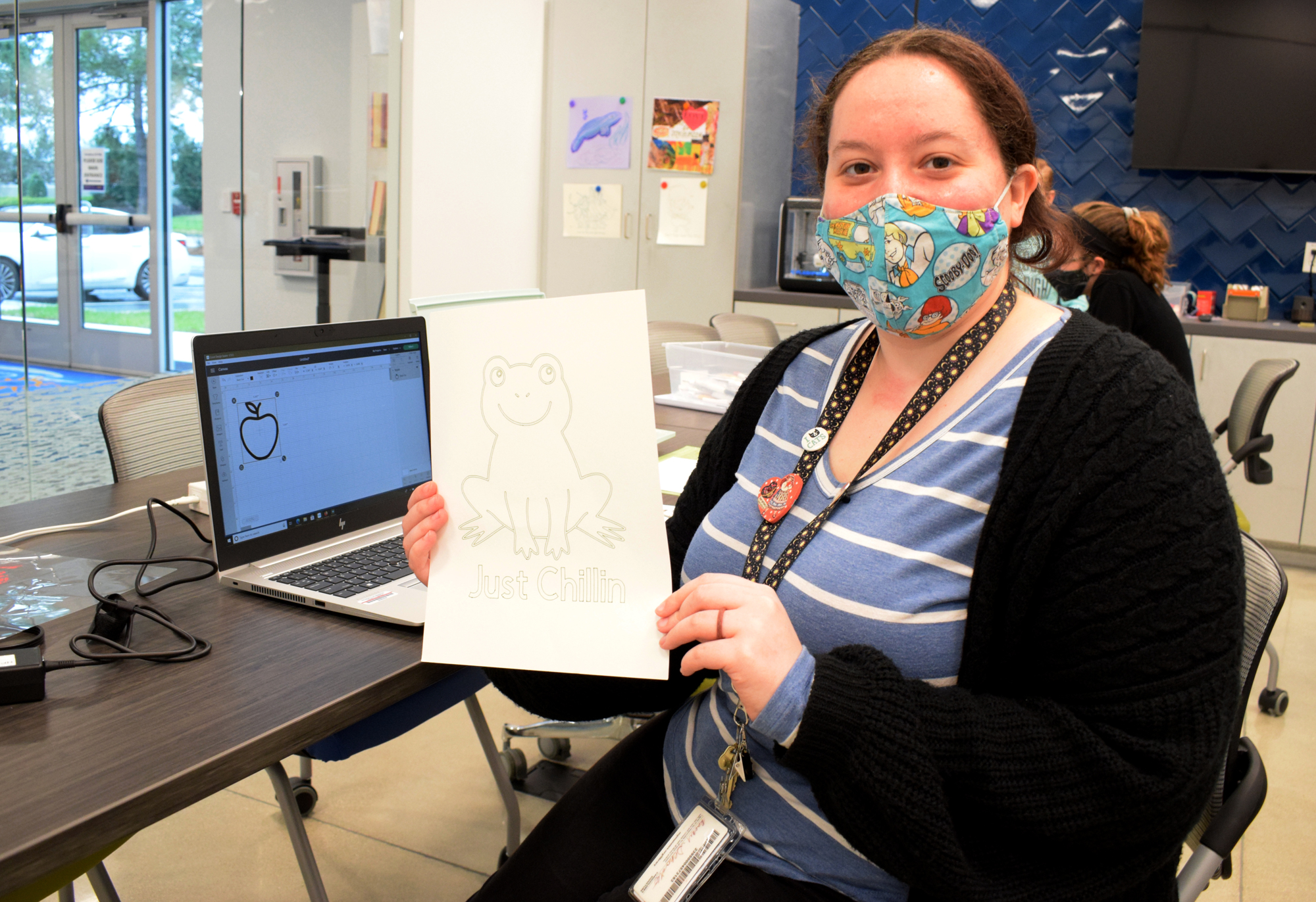 Rachel Scharbo, a library assistant, shows off one of the projects she made in Studio 70.
