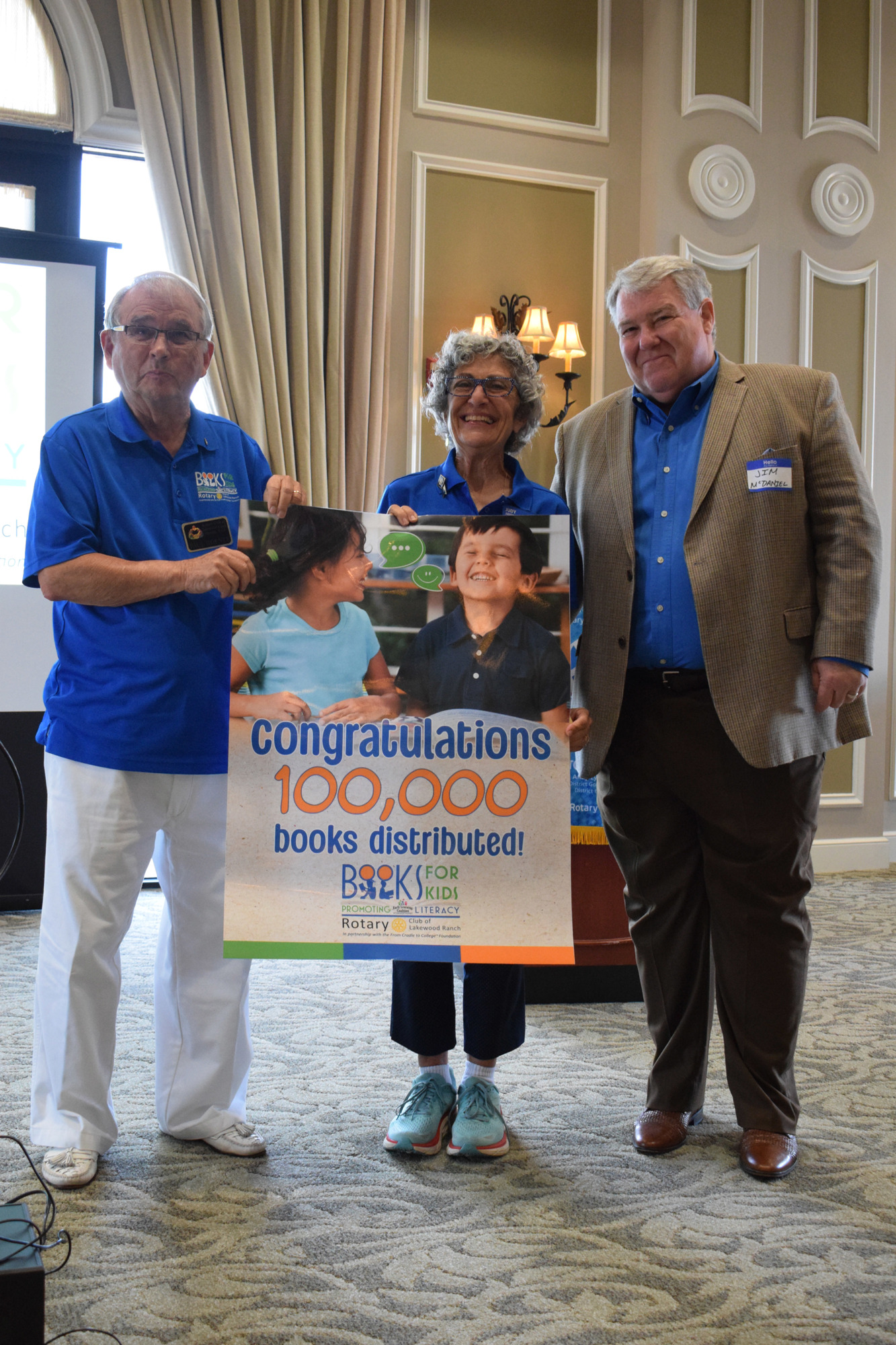 Rotary Club of Lakewood Ranch members Paul Hoenle and Judy Berlow and Jim McDaniel, the president of the Anna Maria Rotary Club and former Lakewood Ranch rotarian, celebrate the Books for Kids program distributing 100,000 books.