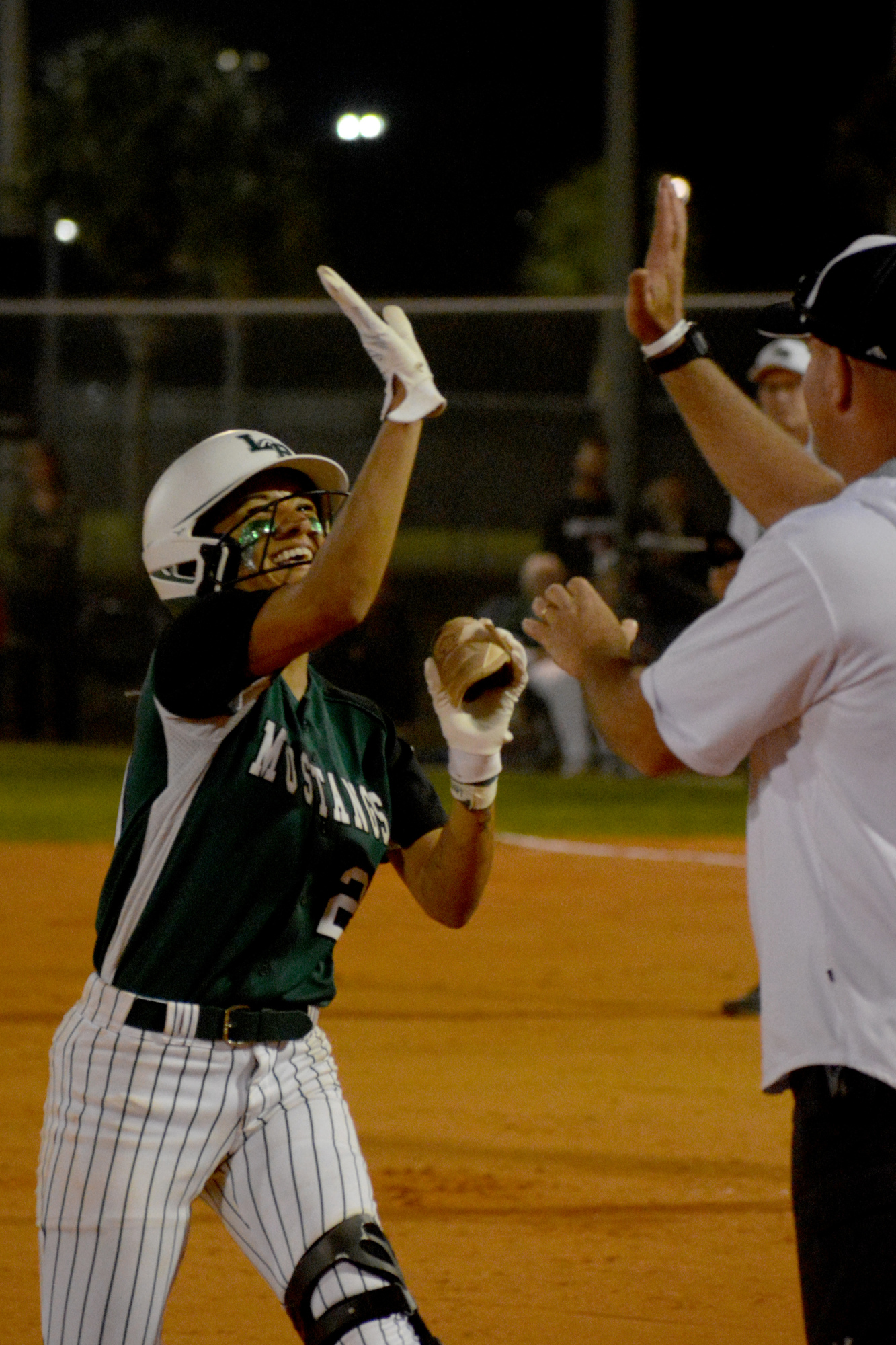 Mustangs senior Sydney McCray high-fives Coach TJ Goelz after hitting a two-run double against Inspiration Academy.