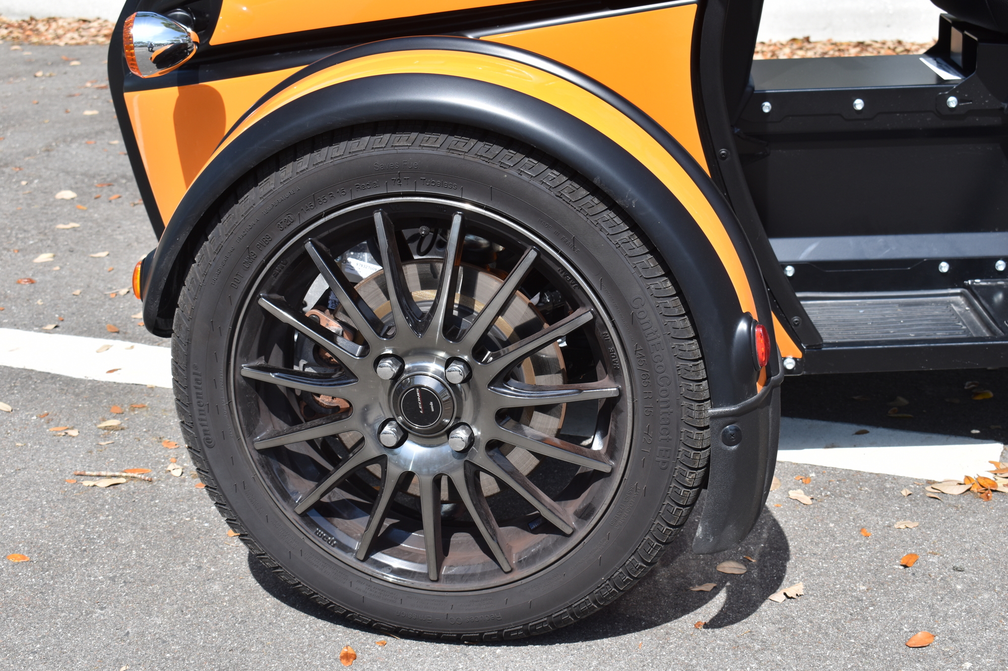 The vehicle rides on traditional automotive wheels and tires. Just three of them.