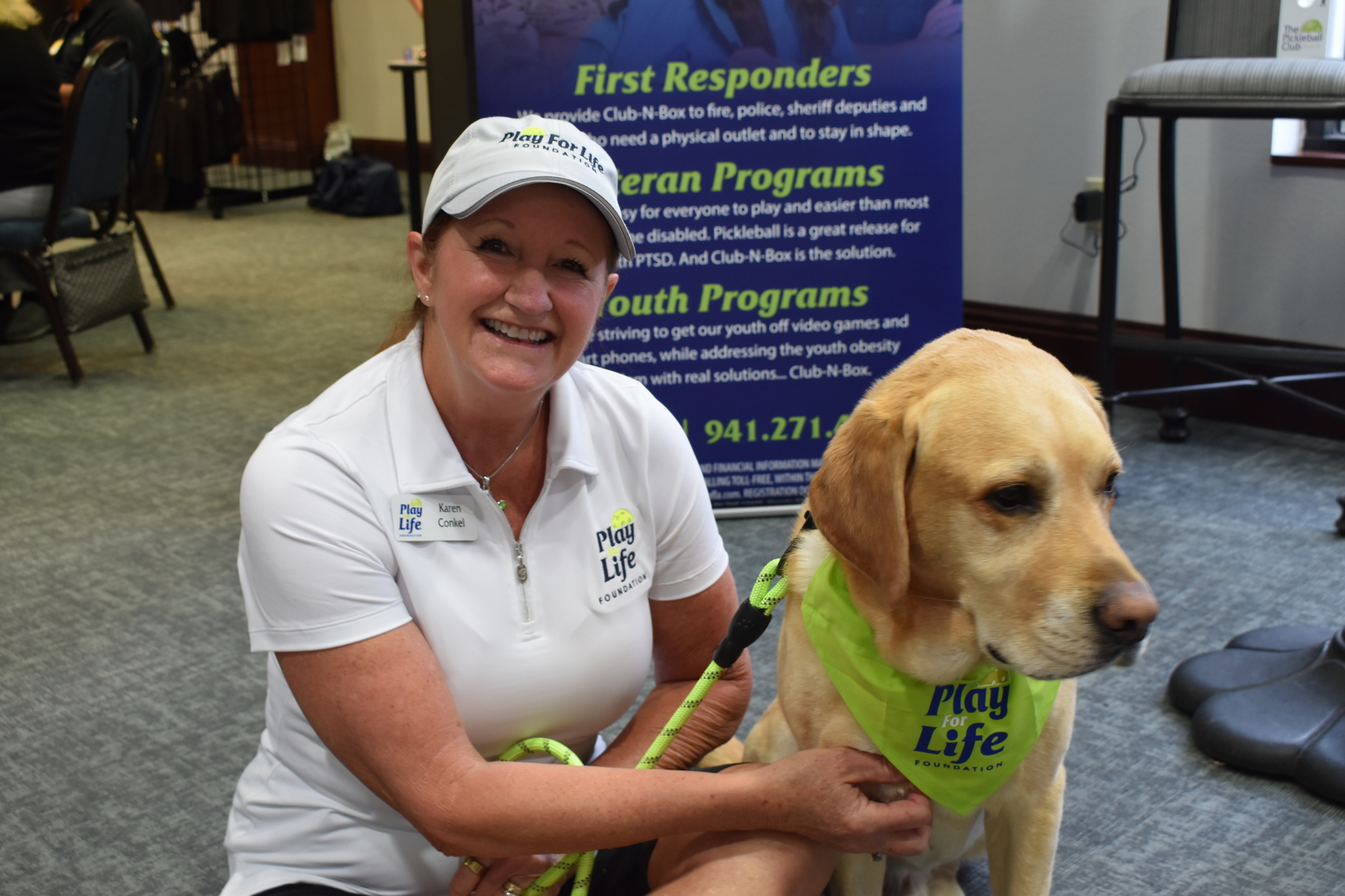 Karen Conkel of Inlets, a board member of the Play for Life foundation, greets visitors alongside the organization's mascot, Levi.