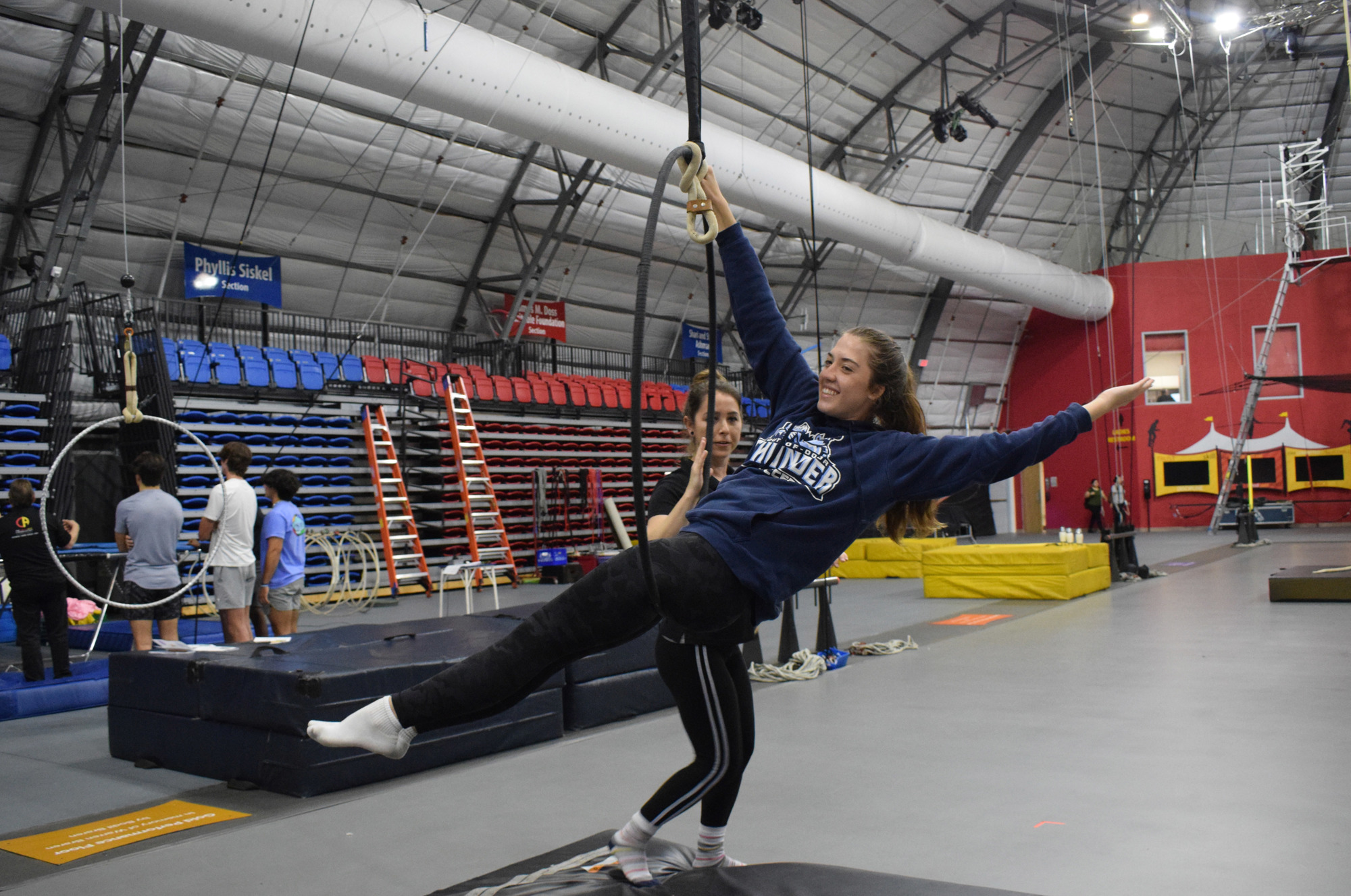 Junior Emma Bonacuse tries to put her body in a straight line while hanging onto the Lyra Hoop.