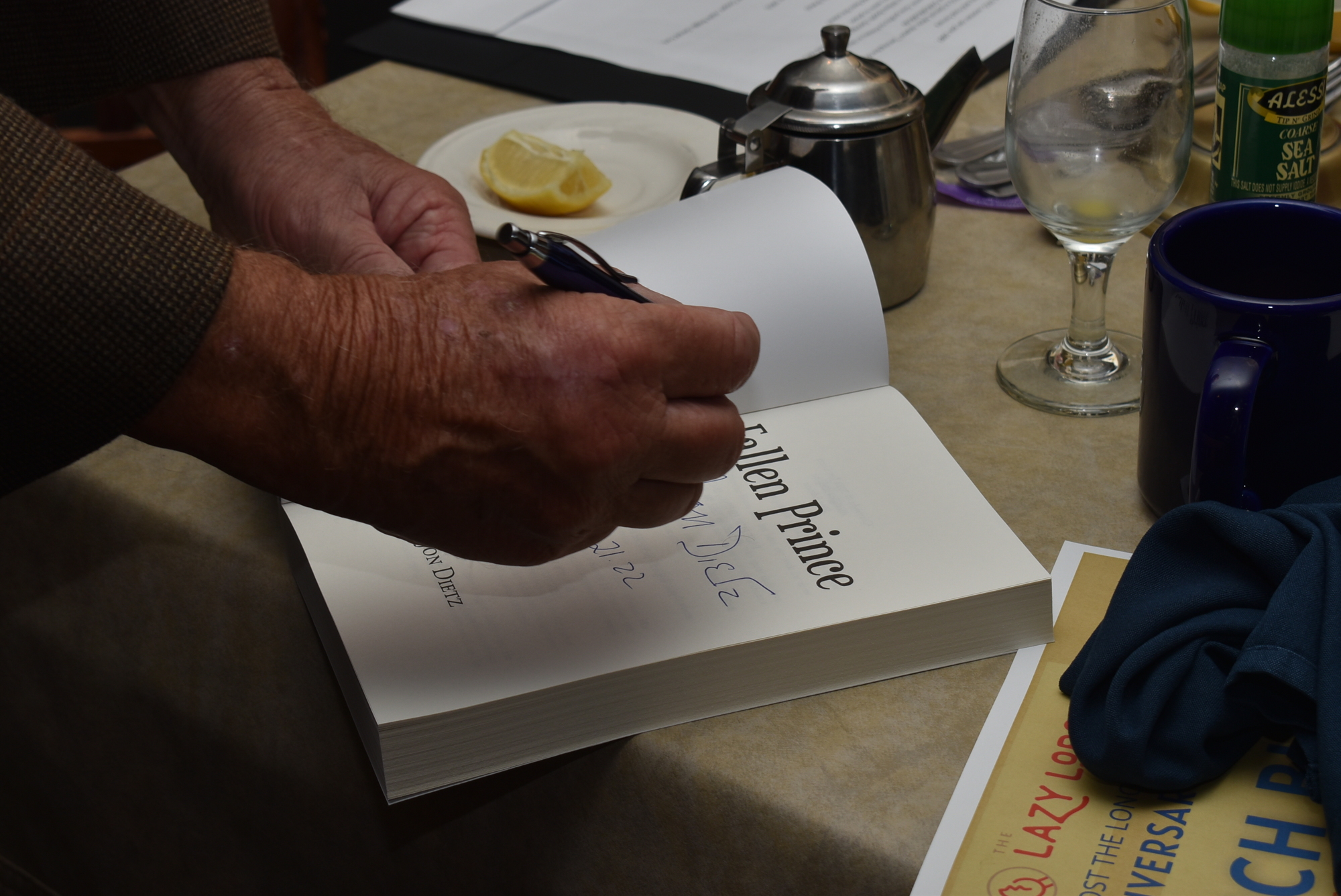 Jon Dietz signs a copy of his book. He donated all proceeds from April 21 to a Kiwanis club in Kiev, Ukraine.
