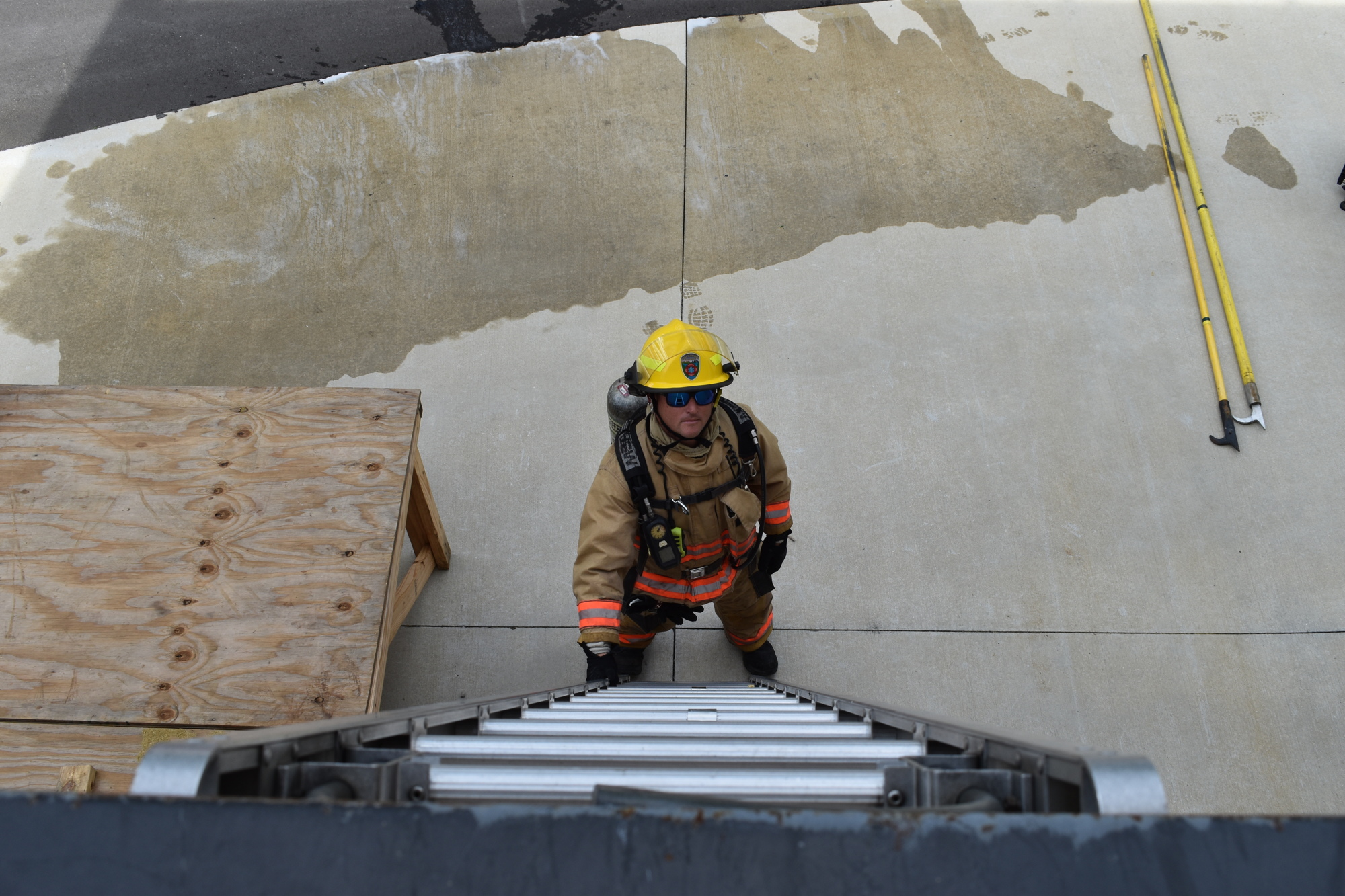 During a training exercise, firefighter Ryan Berggren places a ladder against a window as an exit for other firefighters.