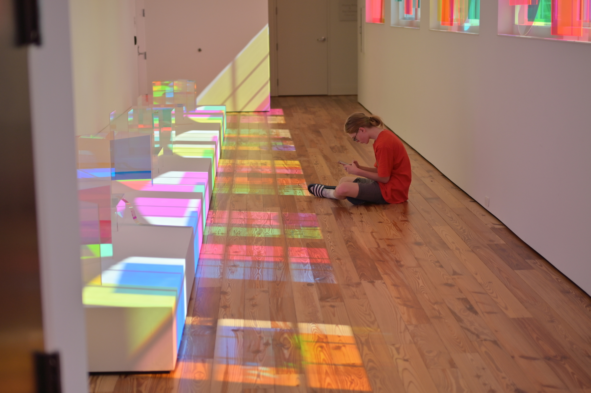 A visitor to the display sits in the refracted light from Vita in Motu's glass. (Photo: Spencer Fordin)