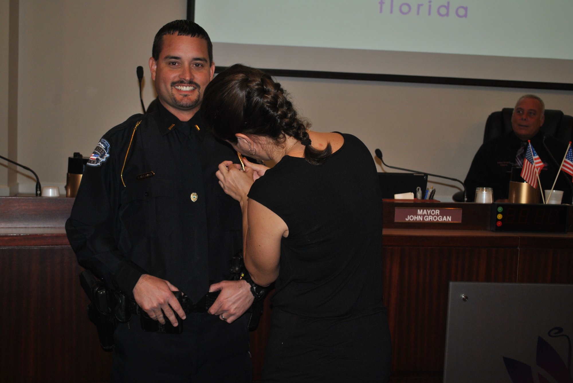 Scott Nylander's wife places a special pin on his uniform to signify his promotion to lieutenant.