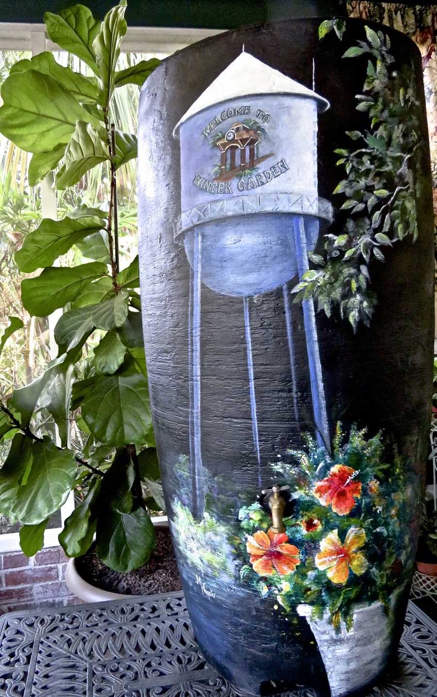 Marian Wagster painted a Winter Garden scene on a rain barrel included in the silent auction.