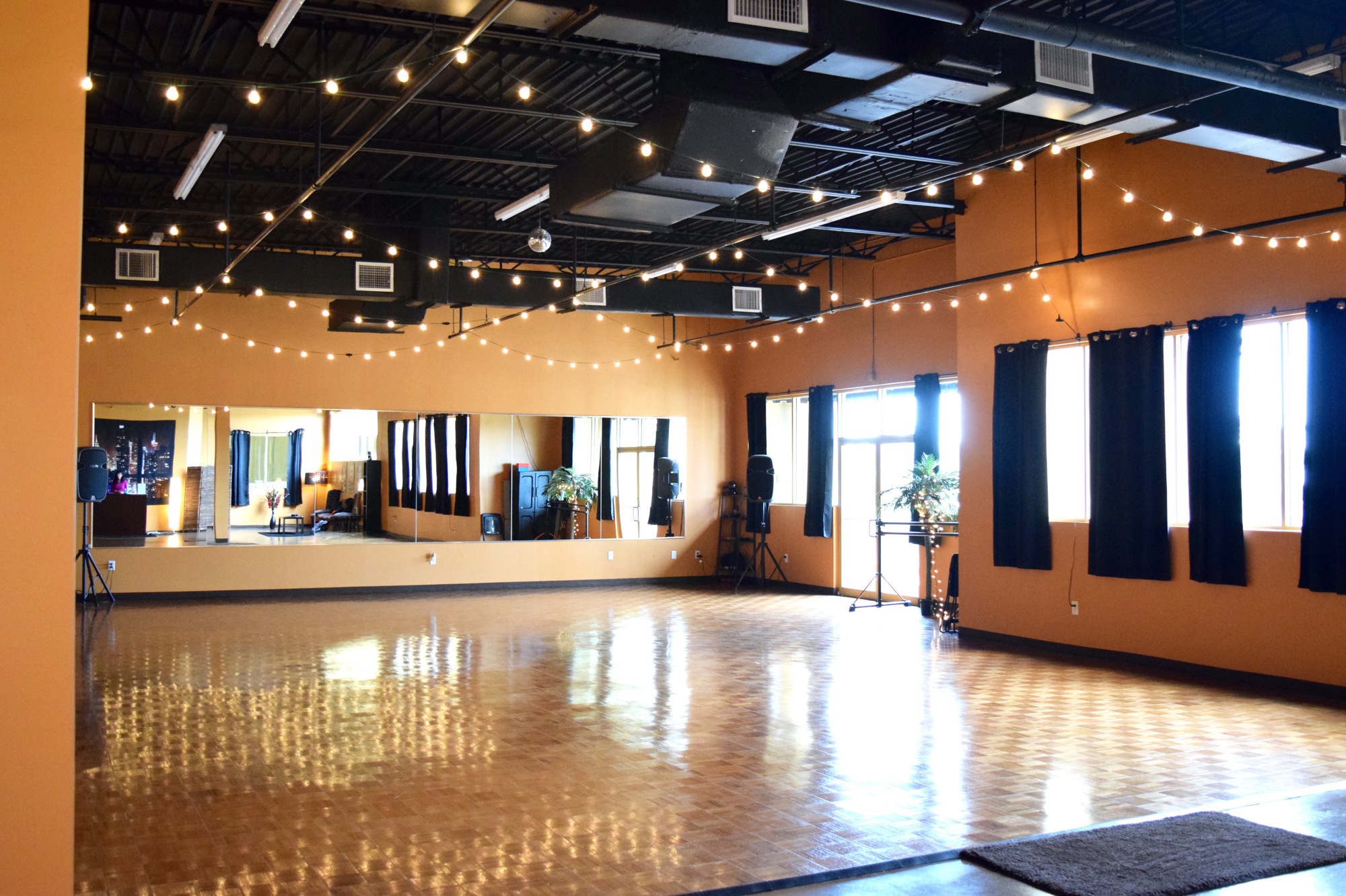 Studio K offers a wide-open fitness area with warm lighting and decorative fairy lights for a relaxed, inviting atmosphere.