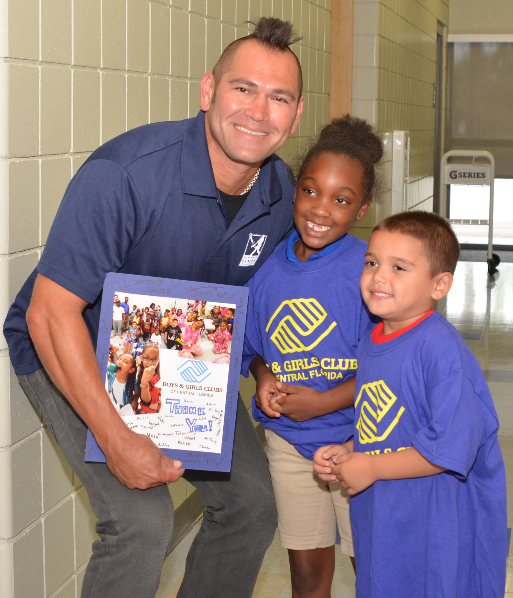 Children in the Boys & Girls Club present a thank-you card to Johnny Damon.