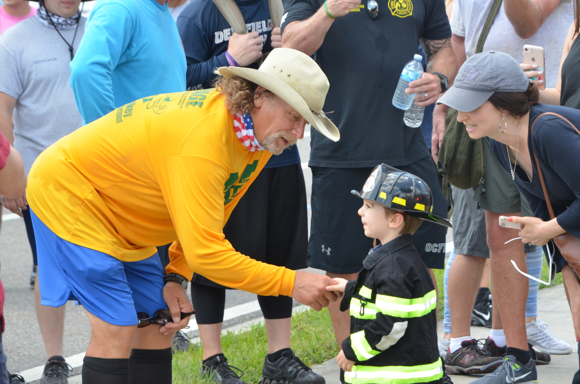 Tom “Bull” Hill stops to hang out with Rory Beiler, dressed as a firefighter, in Winter Garden during a stop on his 650-mile walk to Tallahassee.